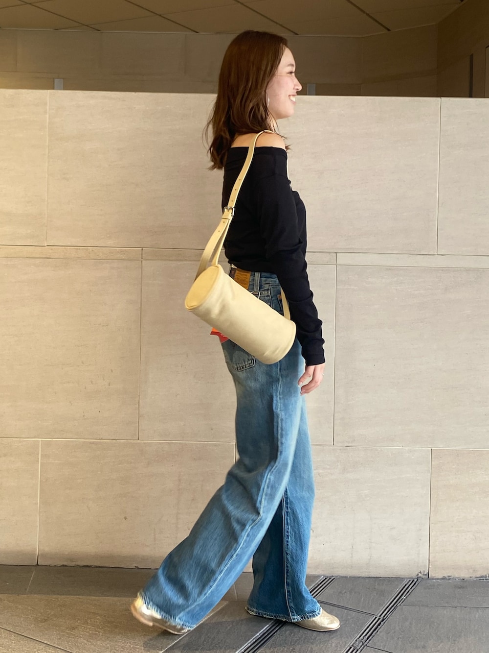 ブルー系のデニムパンツ、ブラック系のTシャツ/カットソー、ゴールド系のバレエシューズを着用したレディースの夏コーディネートの2枚目の写真