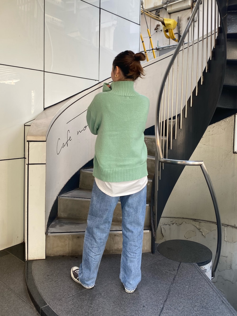 ブルー系のデニムパンツ、グリーン系のニット/セーター、ホワイト系のTシャツ/カットソーを着用したレディースの秋コーディネートの3枚目の写真