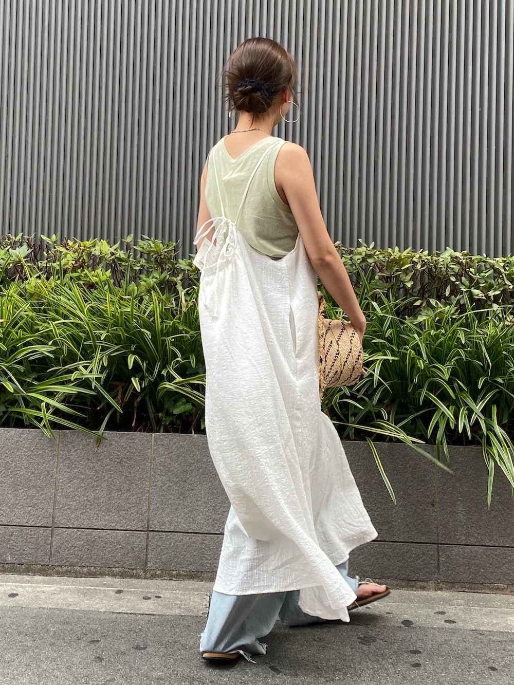 ホワイト系のワンピース、グリーン系のタンクトップ、ブルー系のデニムパンツを着用したレディースの夏コーディネートの2枚目の写真