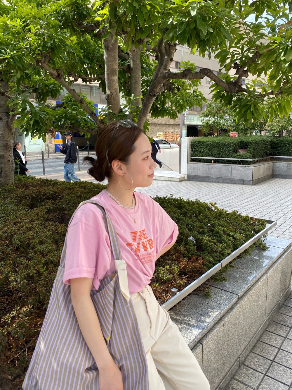 ホワイト系のデニムパンツ、ピンク系のTシャツ/カットソー、ブラック系のサンダルを着用したレディースの春コーディネートの5枚目の写真