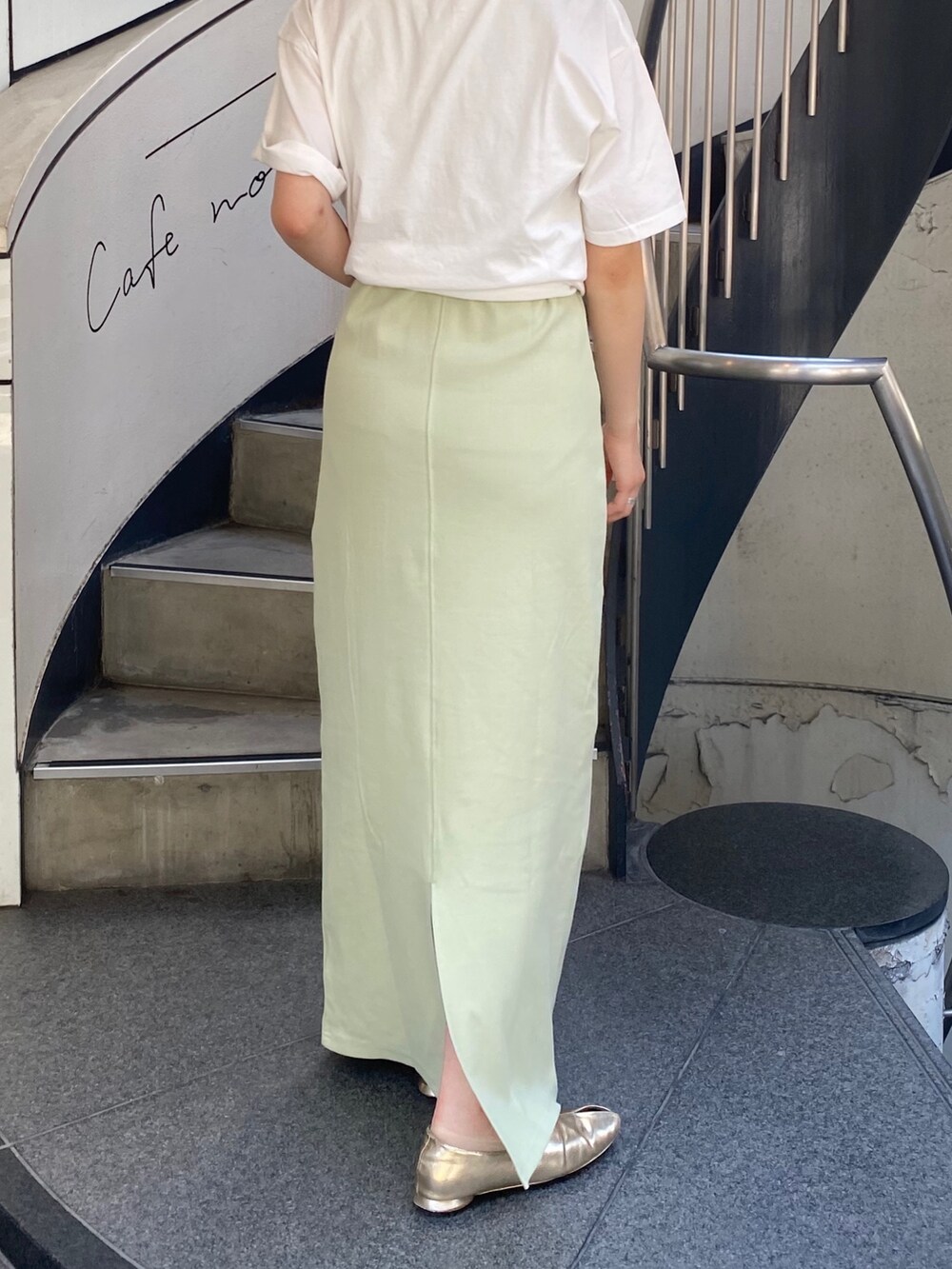 グリーン系のワンピース、ホワイト系のTシャツ/カットソー、シルバー系のハンドバッグを着用したレディースの春コーディネートの2枚目の写真