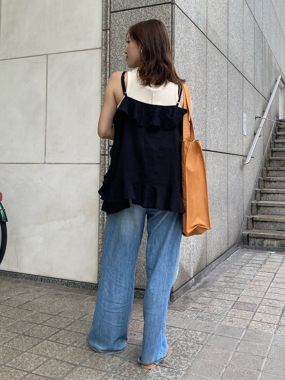 ブルー系のデニムパンツ、ブラック系のキャミソール、ホワイト系のタンクトップを着用したレディースの夏コーディネートの3枚目の写真