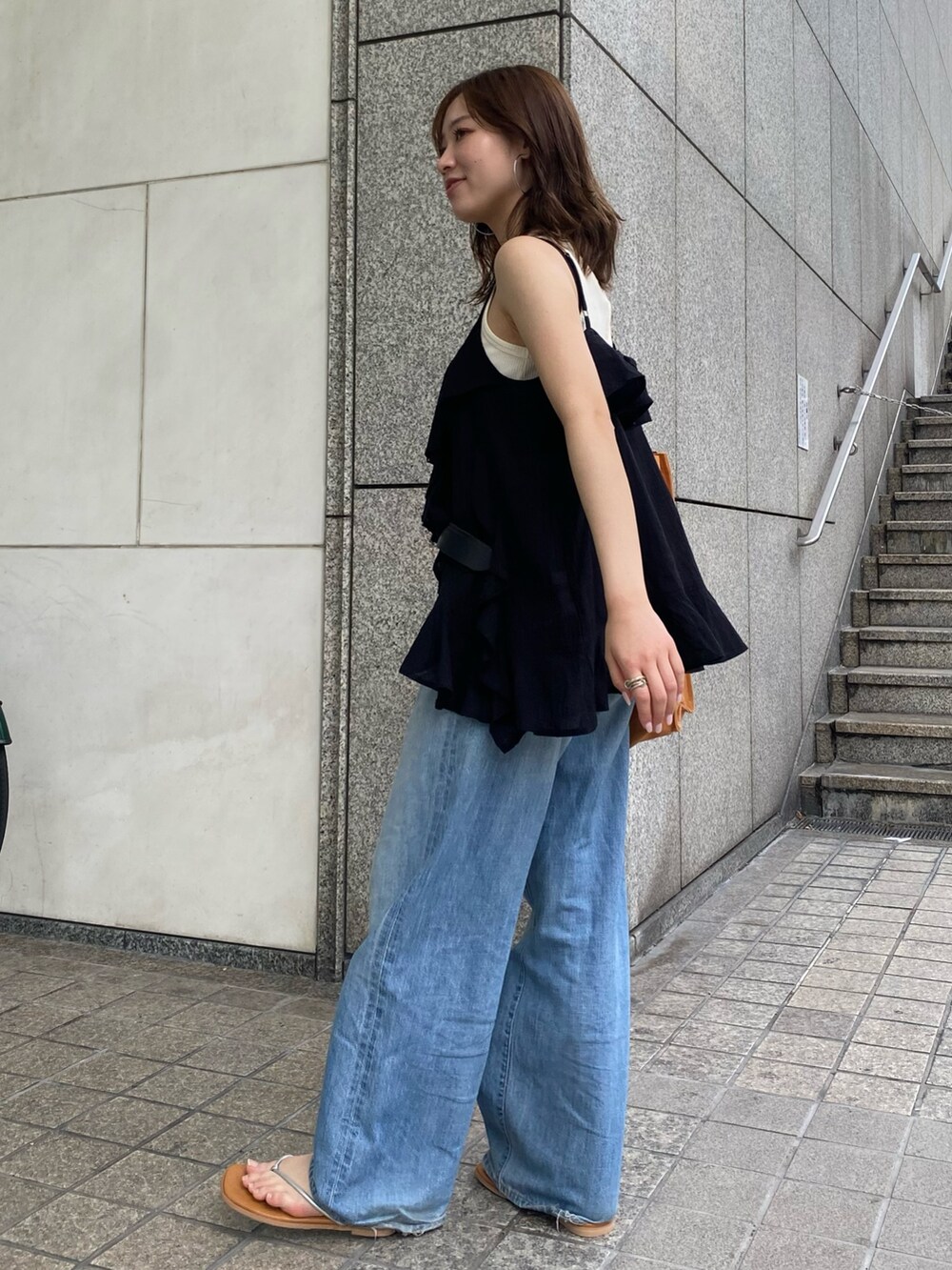 ブルー系のデニムパンツ、ブラック系のキャミソール、ホワイト系のタンクトップを着用したレディースの夏コーディネートの2枚目の写真