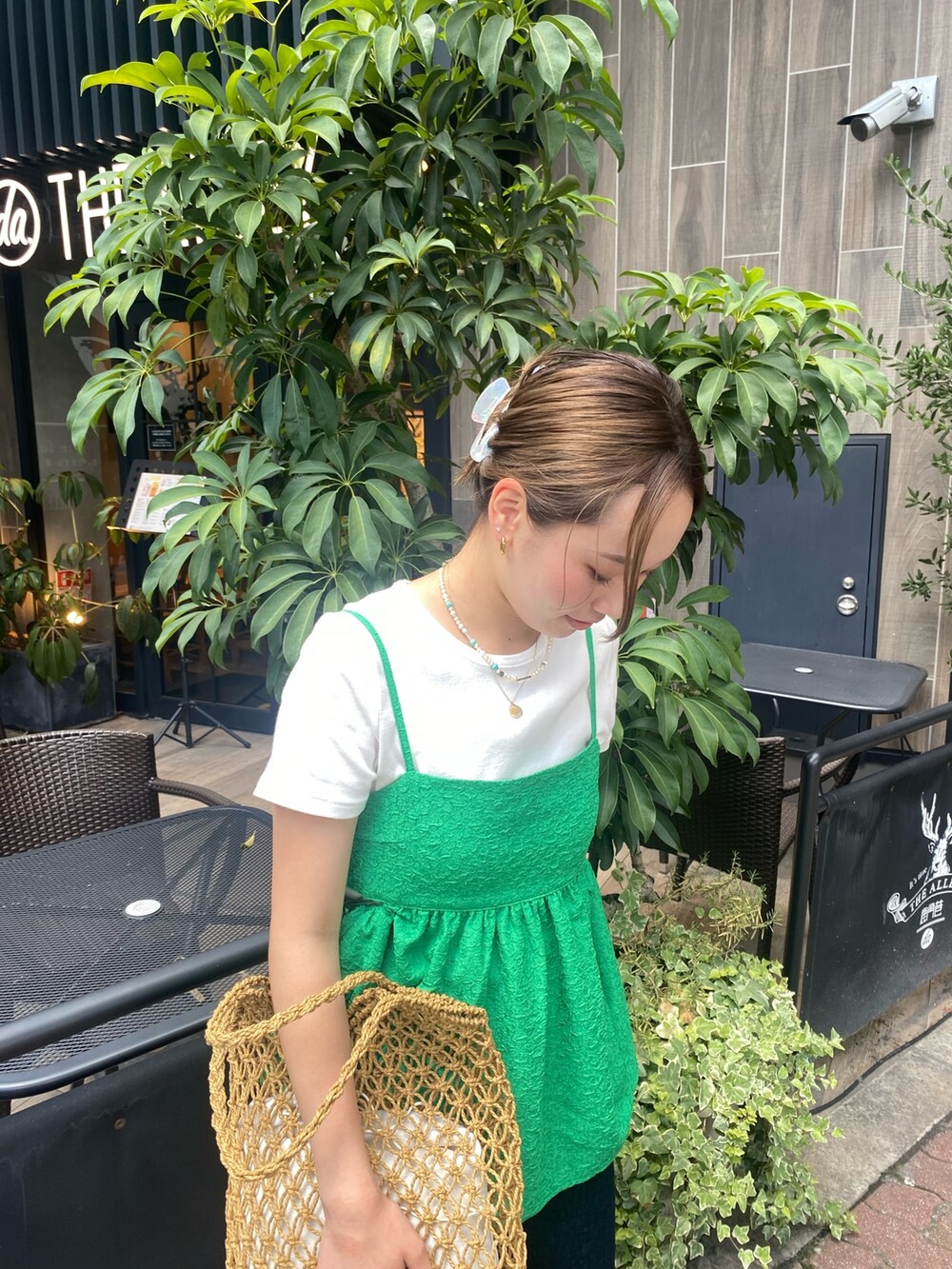 ホワイト系のTシャツ/カットソー、ブルー系のデニムパンツ、ブラウン系のハンドバッグを着用したレディースの夏コーディネートの2枚目の写真