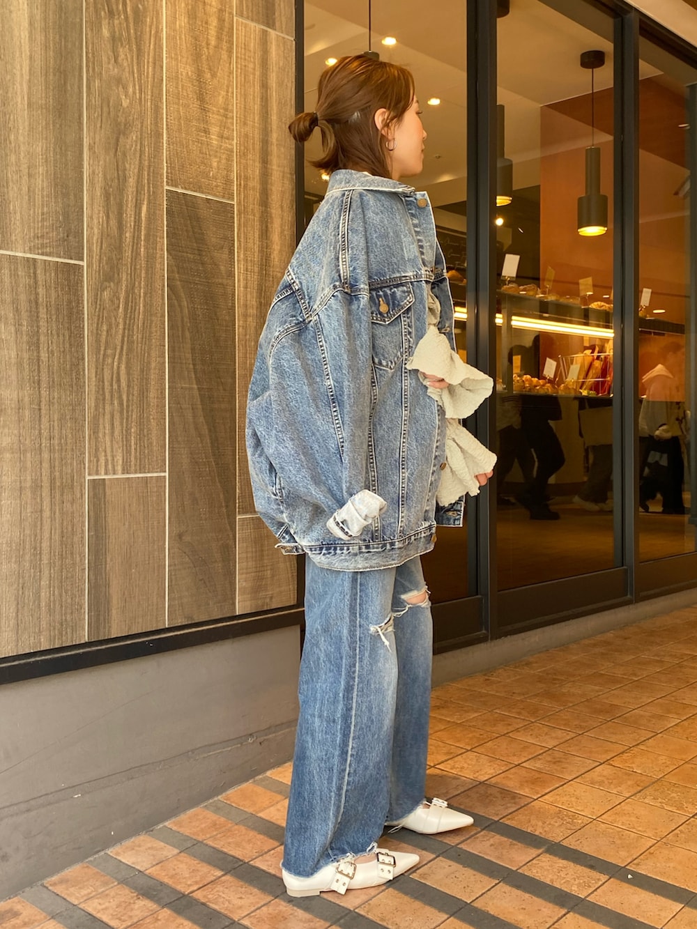 ブルー系のデニムジャケット、グリーン系のシャツ/ブラウス、ブルー系のデニムパンツを着用したレディースの春コーディネートの2枚目の写真