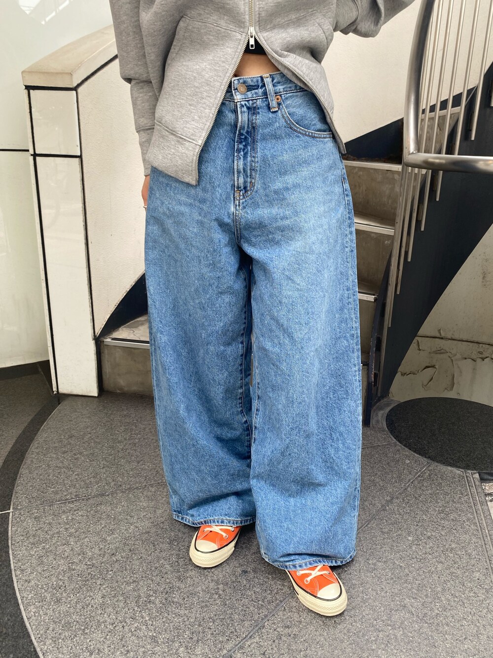 ブルー系のデニムパンツ、グレー系のパーカー、シルバー系のネックレスを着用したレディースの秋コーディネートの5枚目の写真