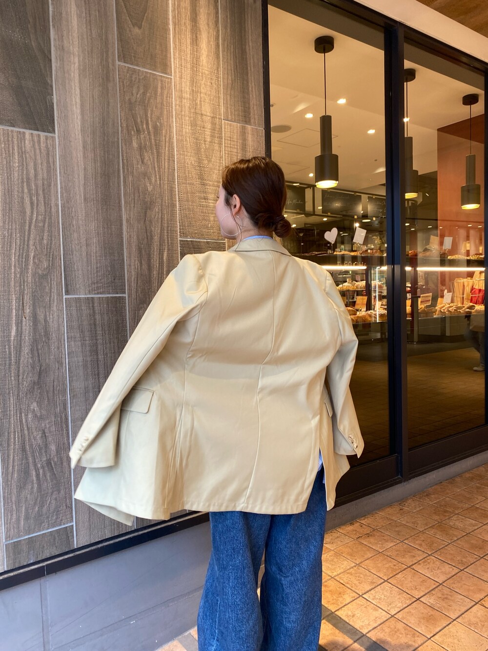 ベージュ系のテーラードジャケット、ブルー系のデニムパンツ、ブラウン系のローファーを着用したレディースの冬コーディネートの4枚目の写真