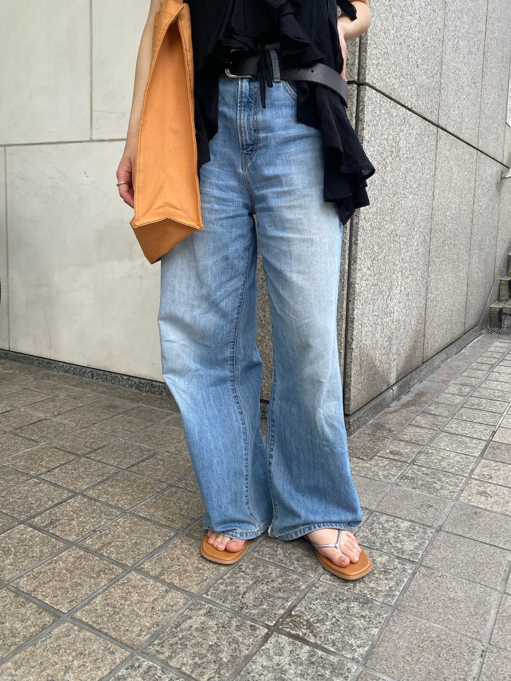 ブルー系のデニムパンツ、ブラック系のキャミソール、ホワイト系のタンクトップを着用したレディースの夏コーディネートの4枚目の写真