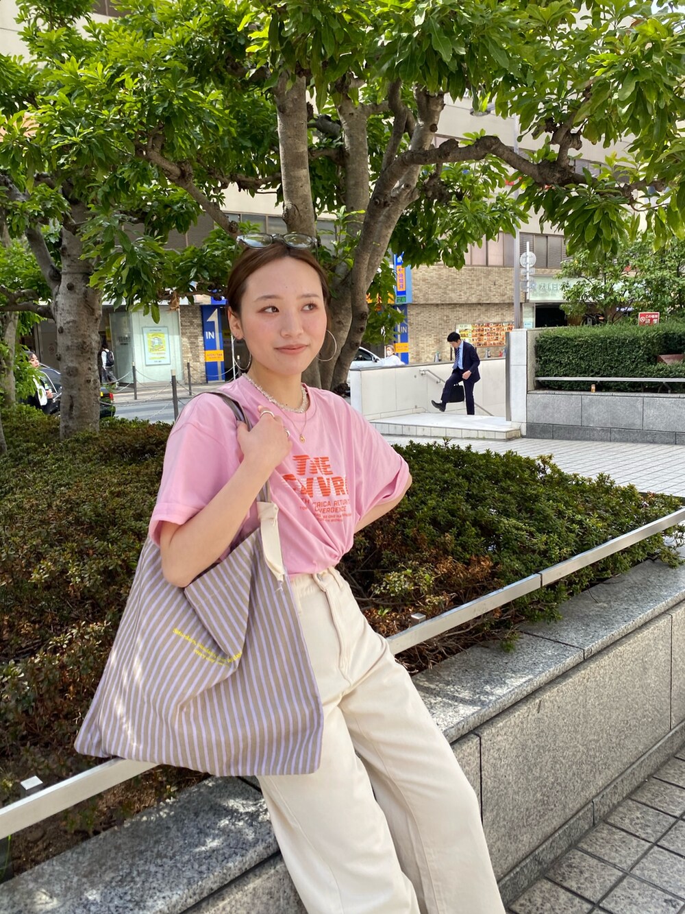 ホワイト系のデニムパンツ、ピンク系のTシャツ/カットソー、ブラック系のサンダルを着用したレディースの春コーディネートの4枚目の写真