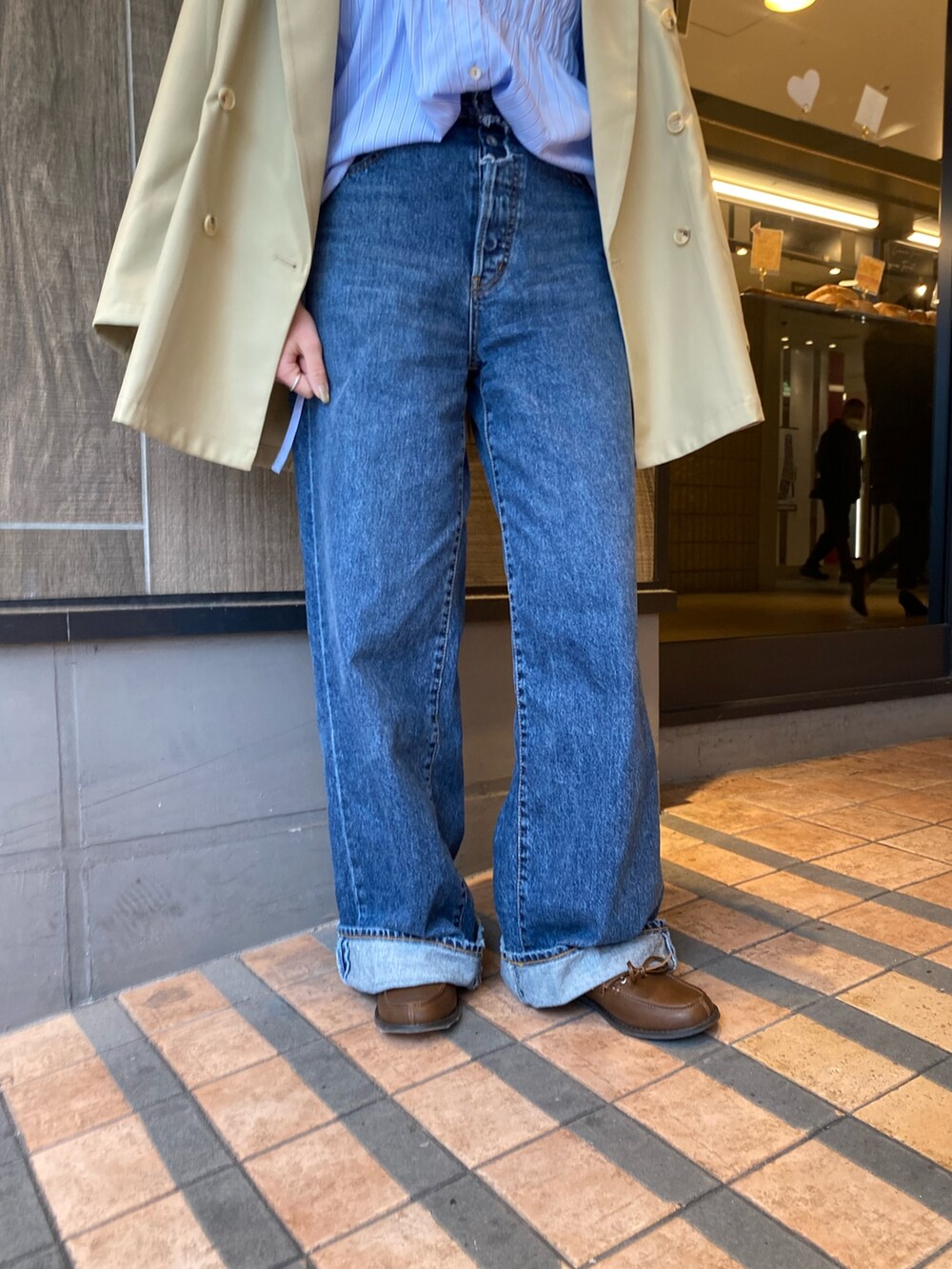 ベージュ系のテーラードジャケット、ブルー系のデニムパンツ、ブラウン系のローファーを着用したレディースの冬コーディネートの7枚目の写真