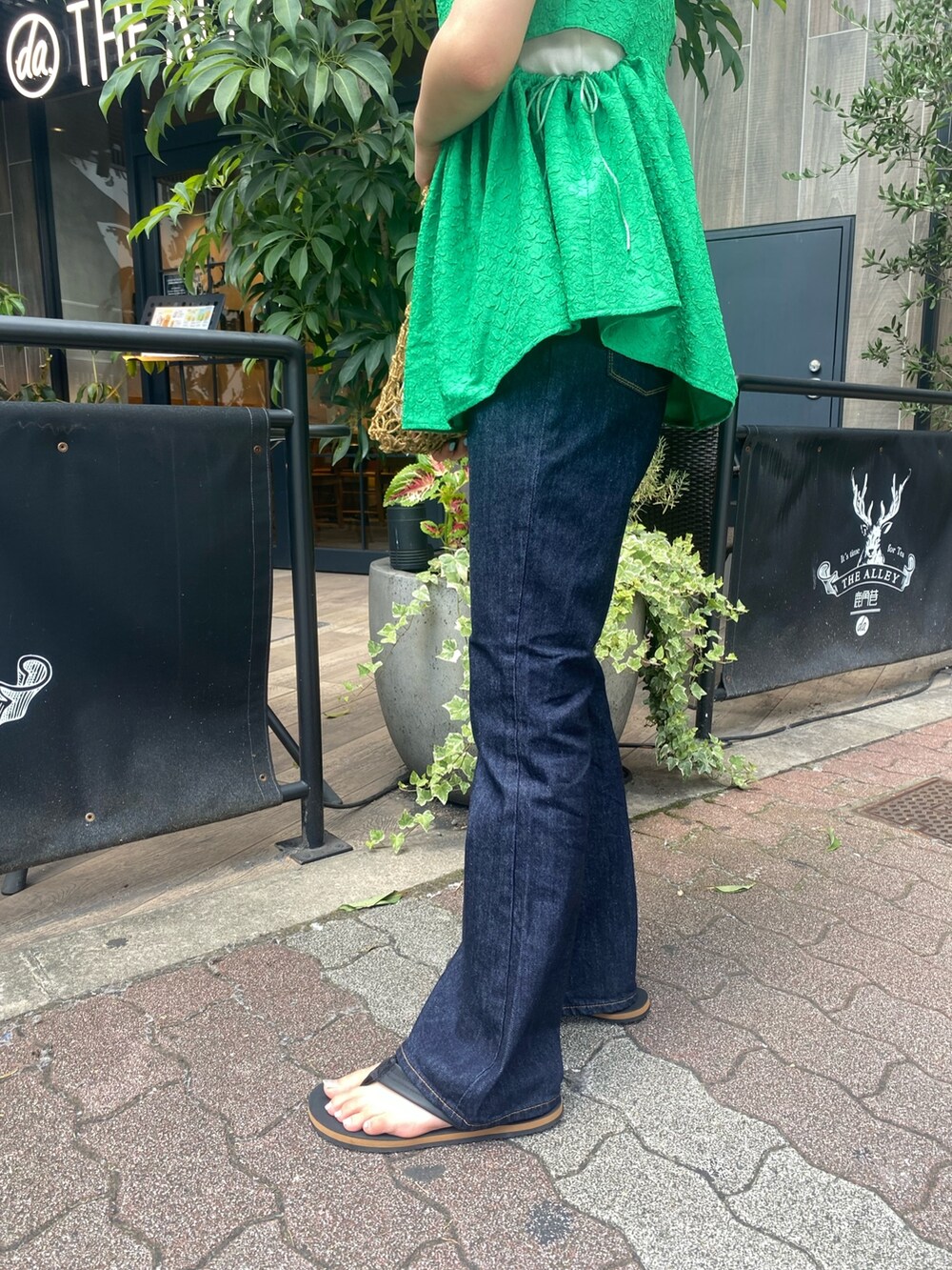 ホワイト系のTシャツ/カットソー、ブルー系のデニムパンツ、ブラウン系のハンドバッグを着用したレディースの夏コーディネートの4枚目の写真