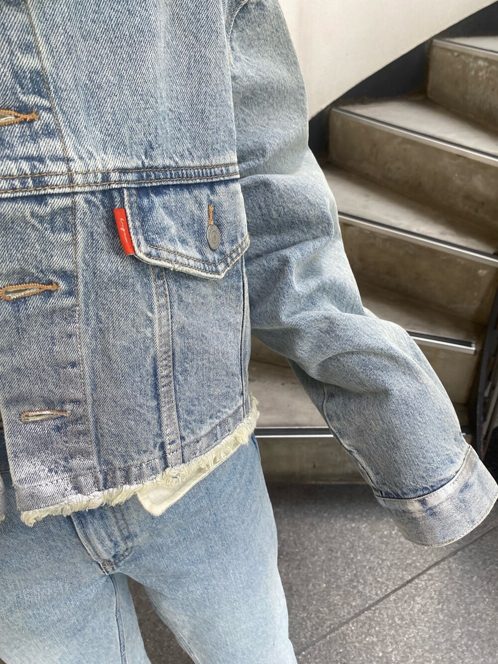 ブルー系のデニムジャケット、ブルー系のデニムパンツを着用したレディースの夏コーディネートの4枚目の写真