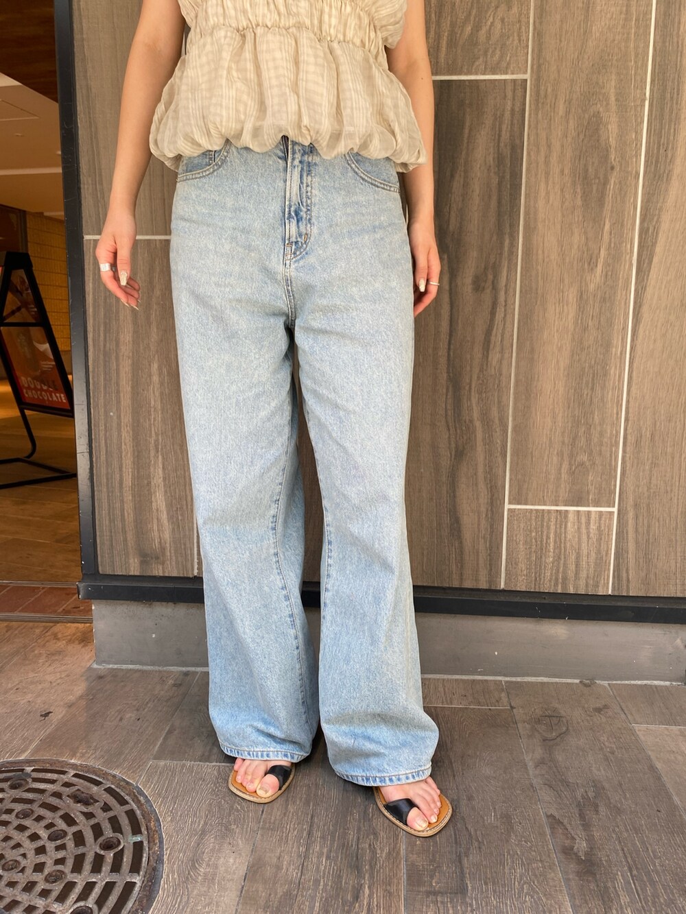 ブラック系のTシャツ/カットソー、ブルー系のデニムパンツ、ブラック系のサンダルを着用したレディースの夏コーディネートの5枚目の写真