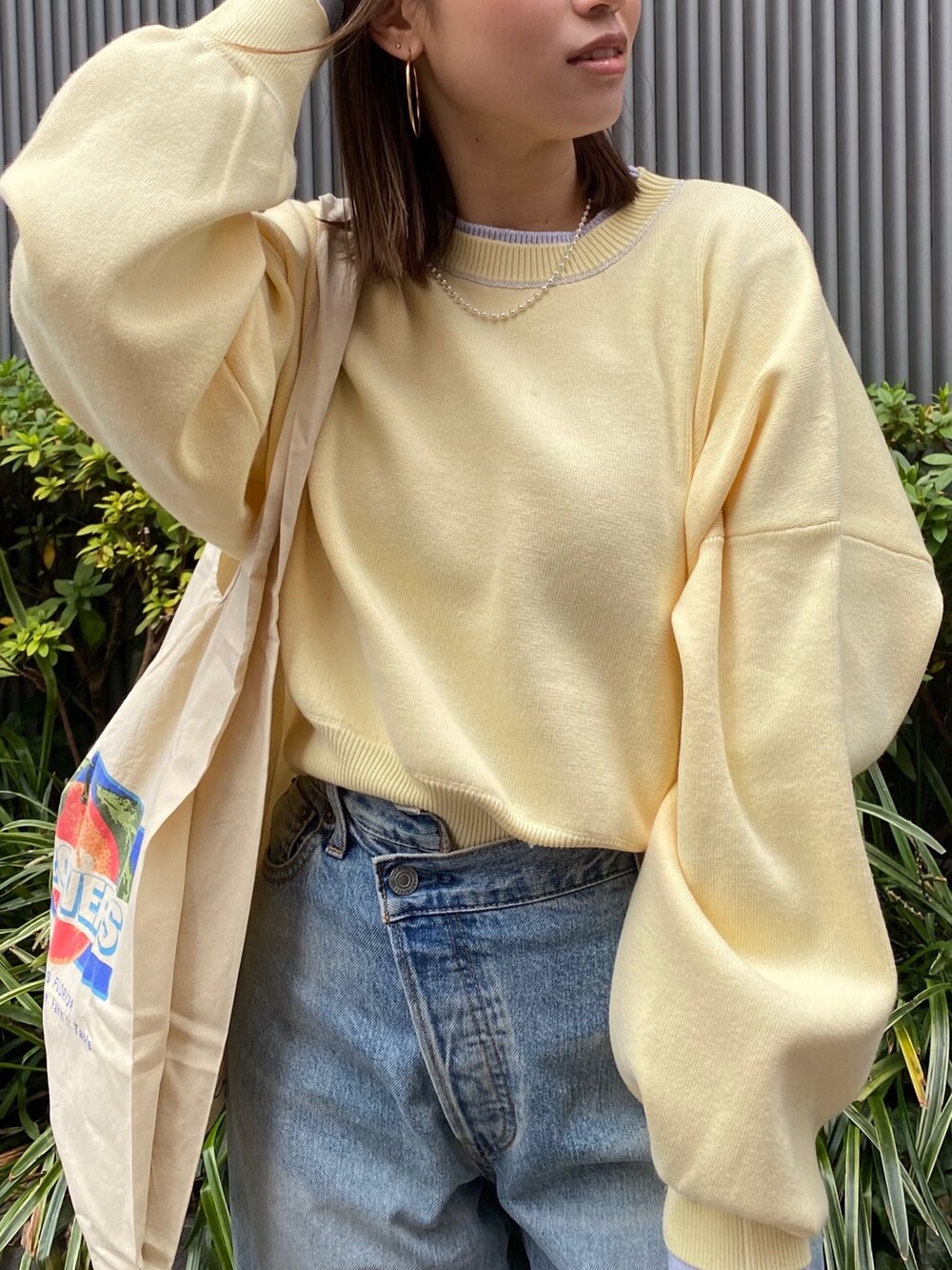 ブルー系のデニムパンツ、ブラック系のブーツ、イエロー系のニット/セーターを着用したレディースの冬コーディネートの4枚目の写真