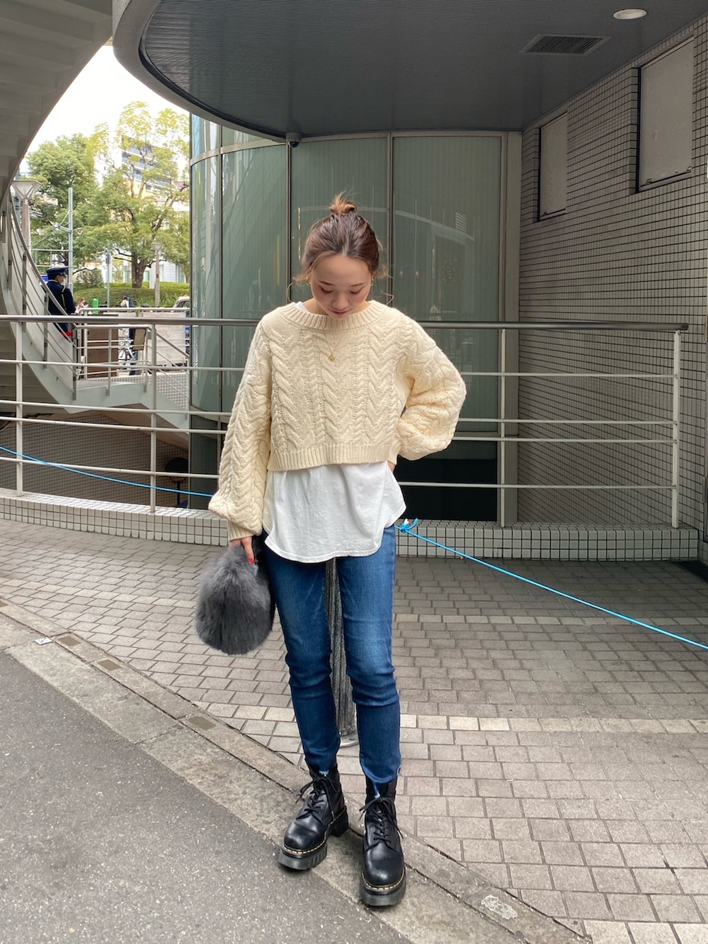 ホワイト系のニット/セーター、ホワイト系のTシャツ/カットソー、ブルー系のデニムパンツを着用したレディースの冬コーディネートの2枚目の写真