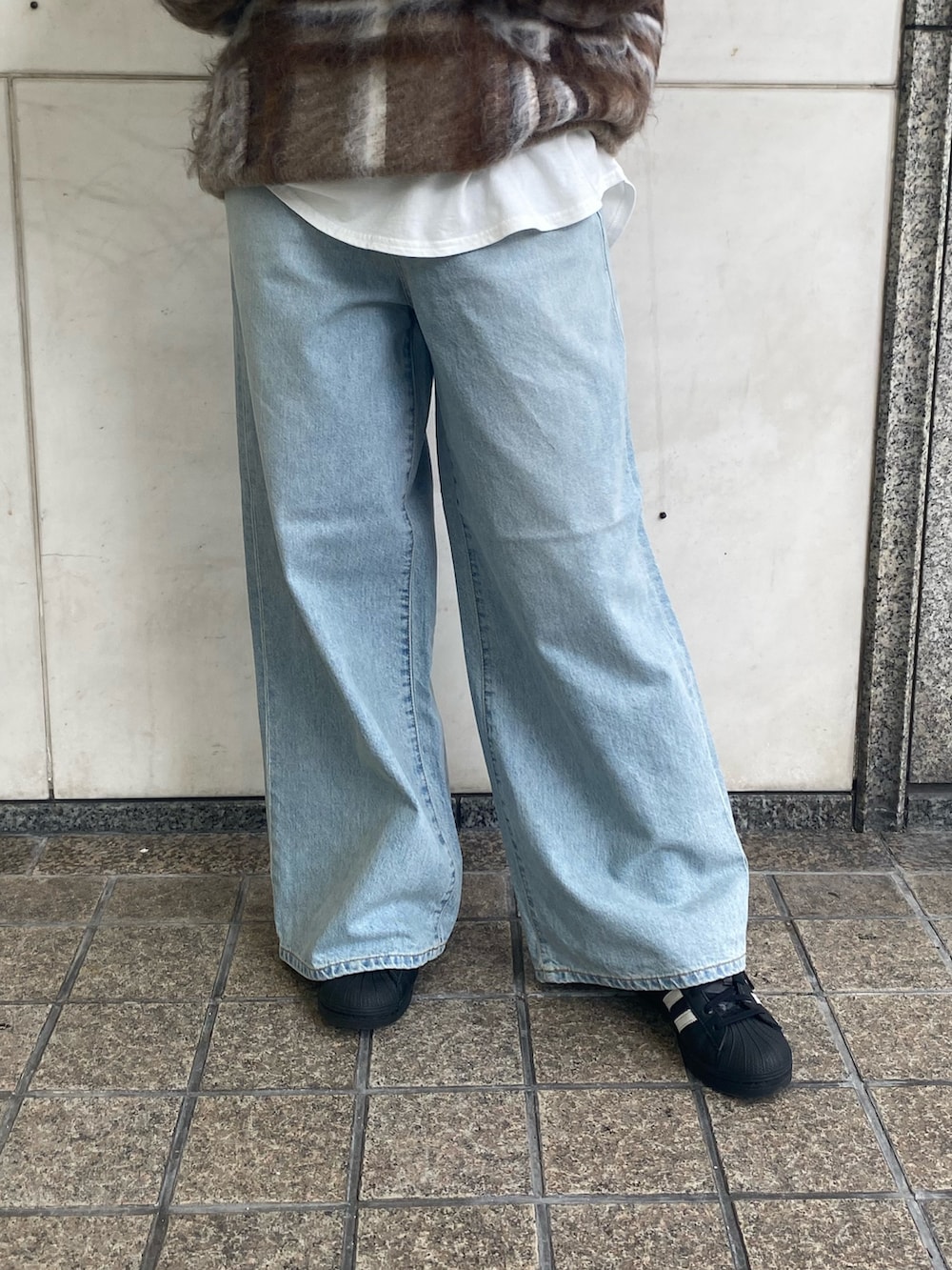 ホワイト系のTシャツ/カットソー、ブルー系のデニムパンツ、ブラウン系のニット/セーターを着用したレディースの秋コーディネートの6枚目の写真