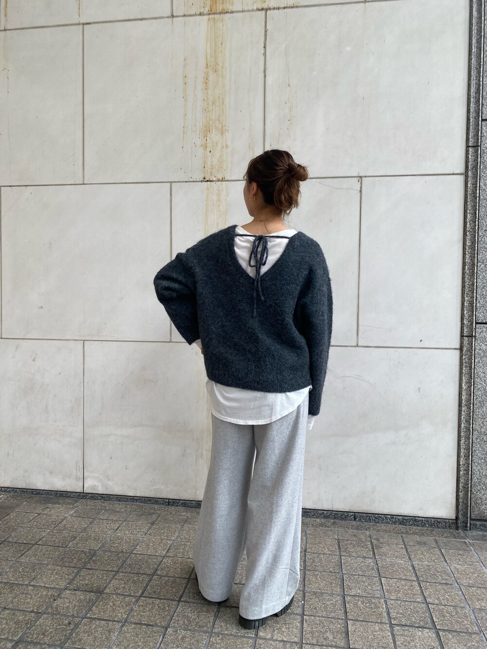 グレー系のニット/セーター、ホワイト系のTシャツ/カットソー、グレー系のその他パンツを着用したレディースの冬コーディネートの3枚目の写真