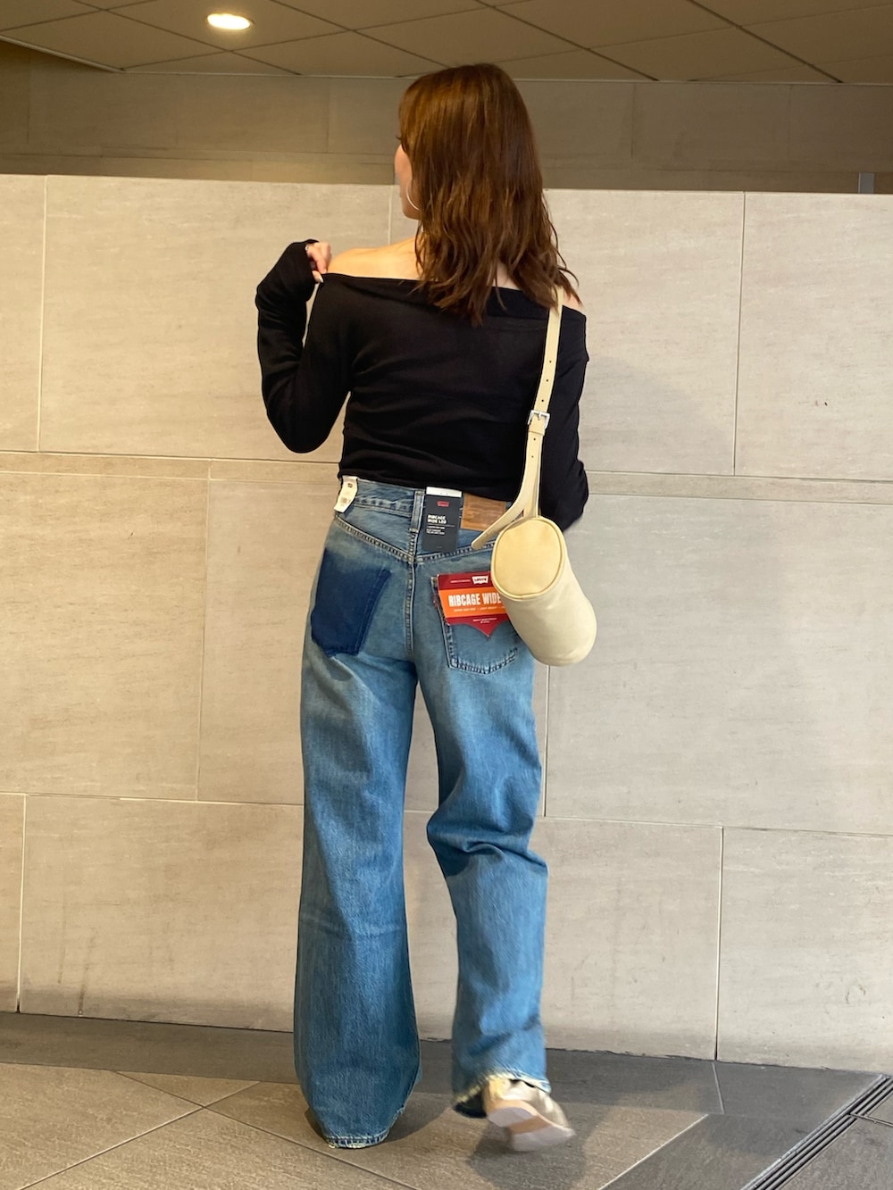 ブルー系のデニムパンツ、ブラック系のTシャツ/カットソー、ゴールド系のバレエシューズを着用したレディースの夏コーディネートの3枚目の写真