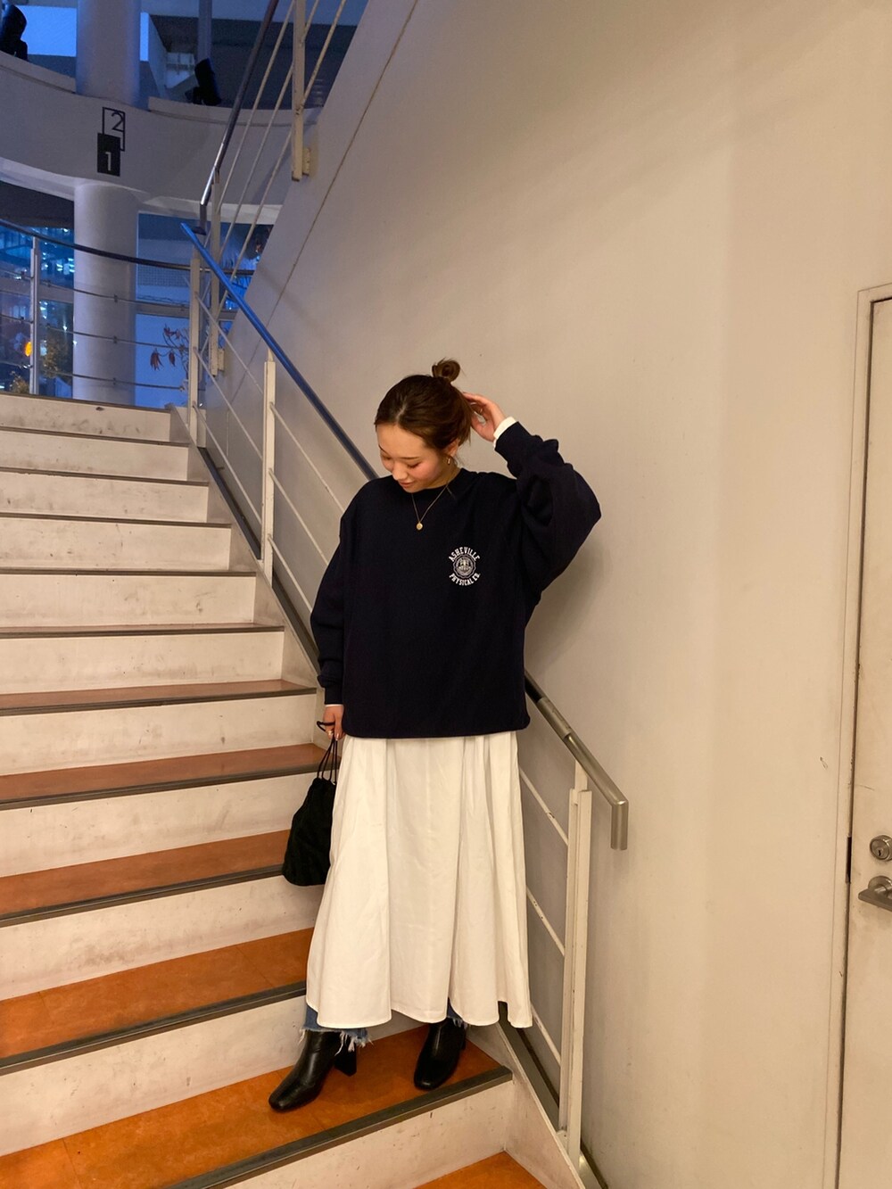 ブルー系のスウェット、ブラック系のワンピースを着用したレディースの秋コーディネートの2枚目の写真