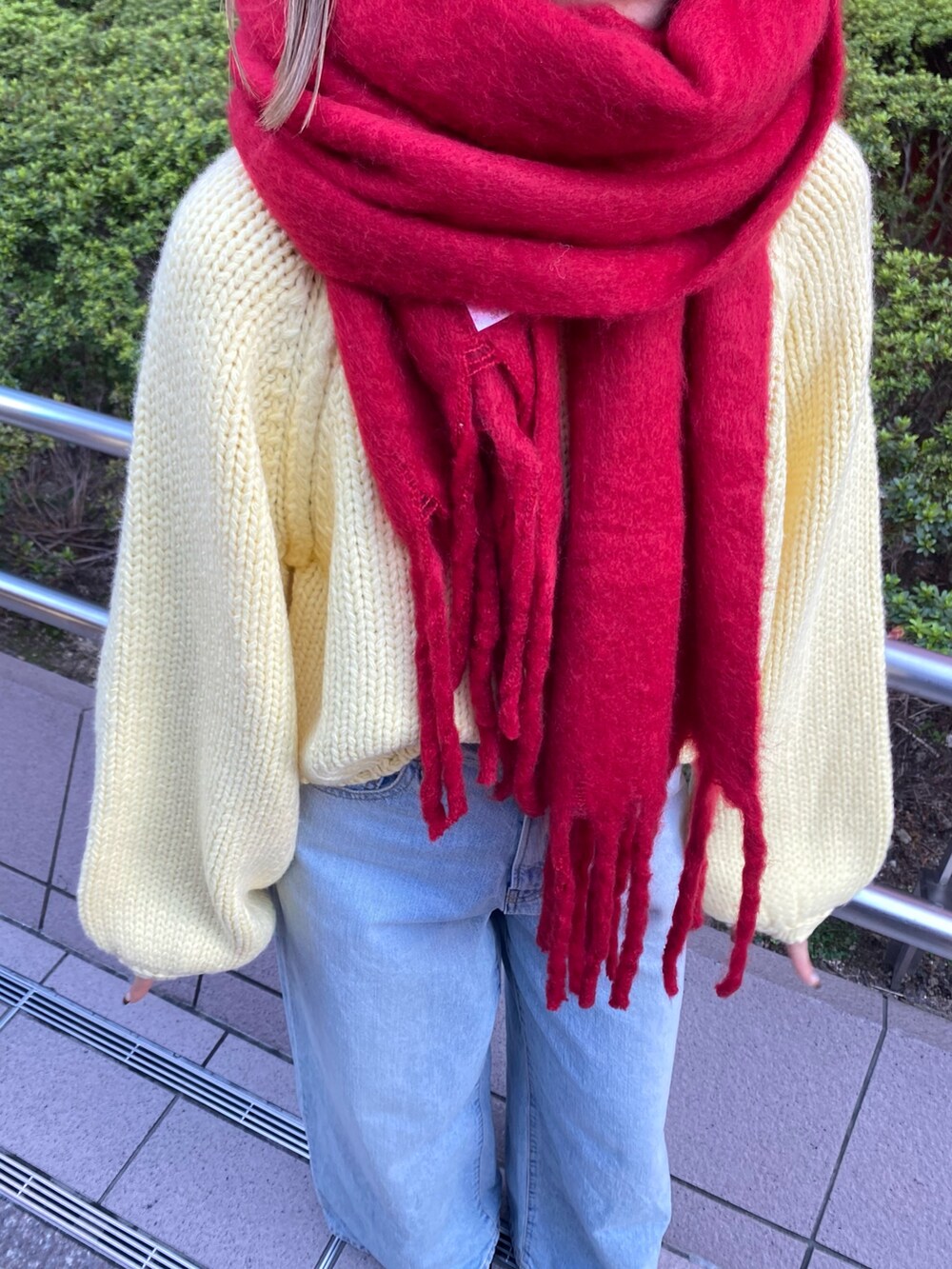 ブルー系のデニムパンツ、イエロー系のニット/セーター、ブラウン系のブーツを着用したレディースの秋コーディネートの8枚目の写真