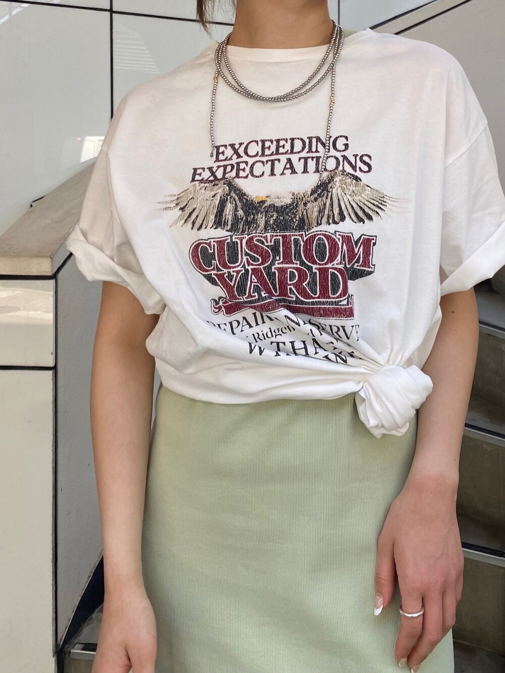 グリーン系のワンピース、ホワイト系のTシャツ/カットソー、シルバー系のハンドバッグを着用したレディースの春コーディネートの4枚目の写真