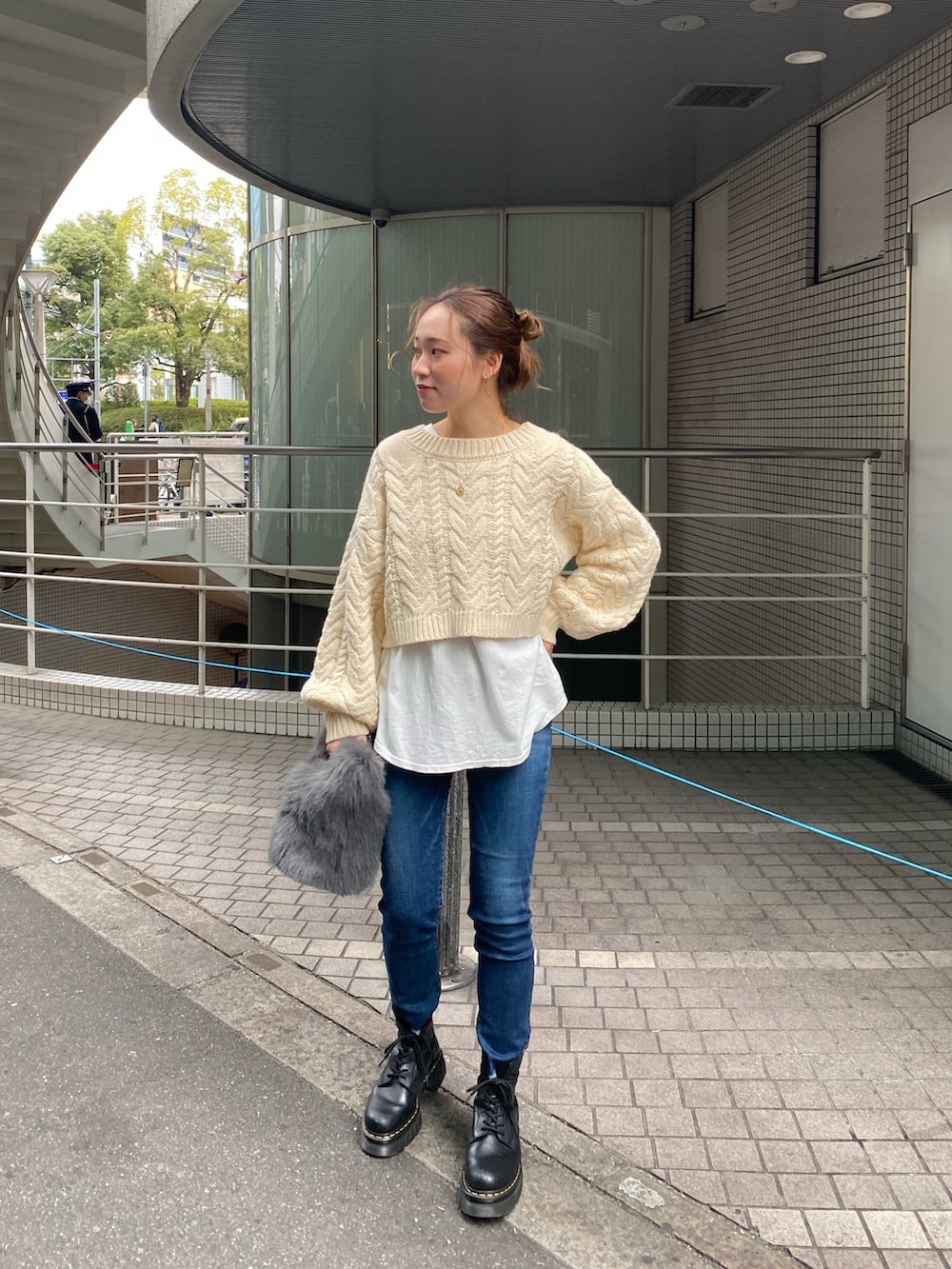 ホワイト系のニット/セーター、ホワイト系のTシャツ/カットソー、ブルー系のデニムパンツを着用したレディースの冬コーディネートの3枚目の写真