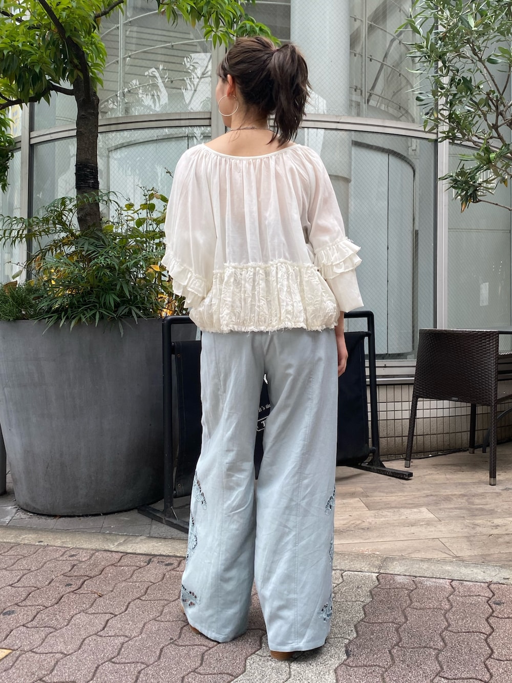 ブルー系のその他パンツ、ブラック系のサンダル、ホワイト系のシャツ/ブラウスを着用したレディースの春コーディネートの3枚目の写真