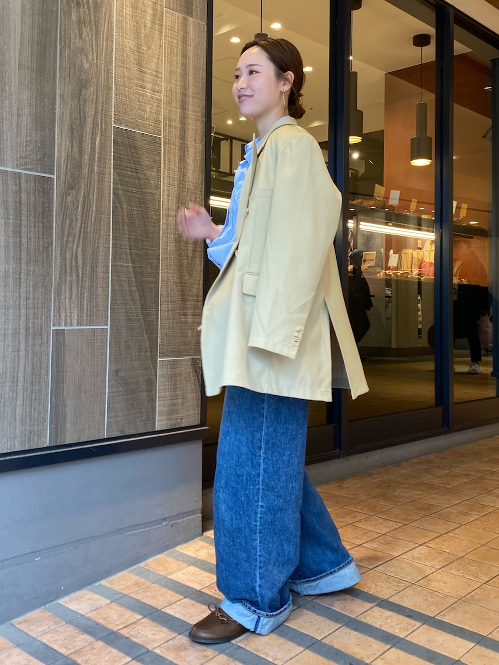 ベージュ系のテーラードジャケット、ブルー系のデニムパンツ、ブラウン系のローファーを着用したレディースの冬コーディネートの2枚目の写真