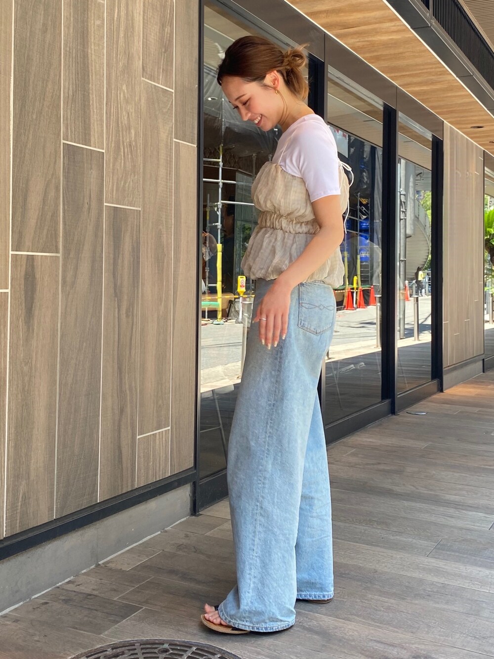 ブラック系のTシャツ/カットソー、ブルー系のデニムパンツ、ブラック系のサンダルを着用したレディースの夏コーディネートの3枚目の写真