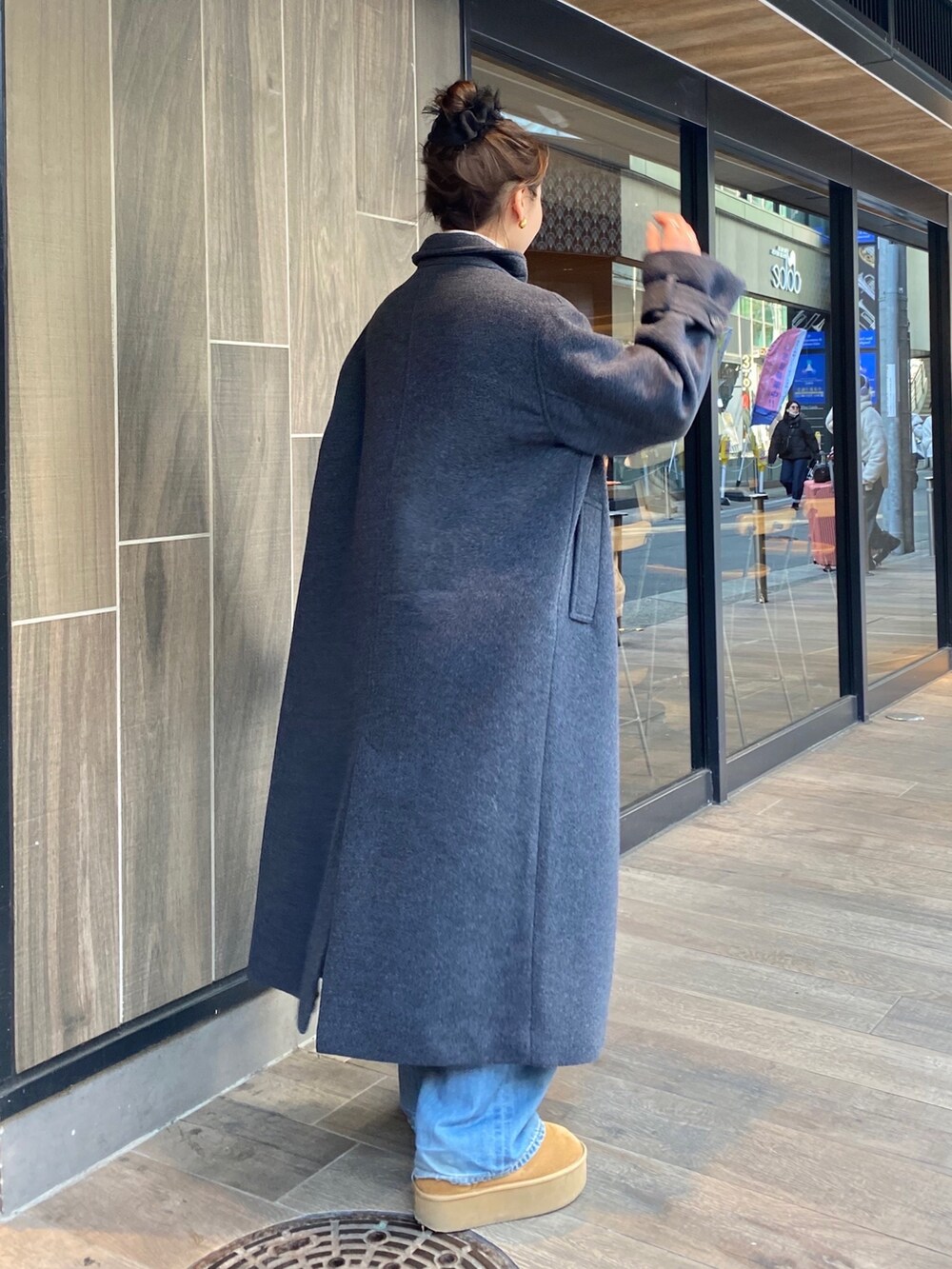 グレー系のその他アウター、ホワイト系のニット/セーター、ブルー系のデニムパンツを着用したレディースの冬コーディネートの3枚目の写真