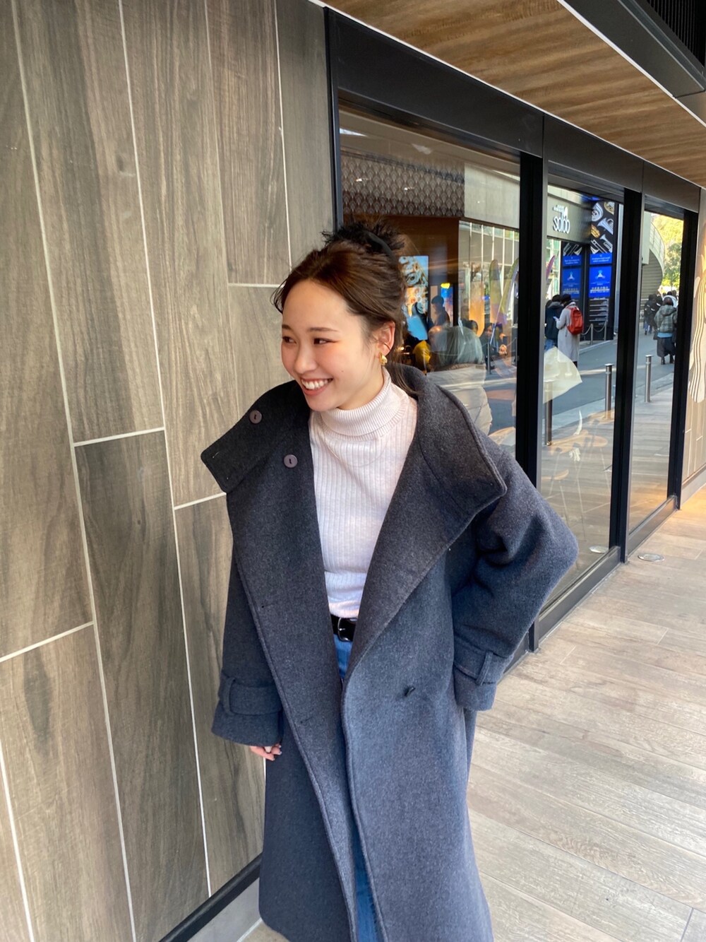 グレー系のその他アウター、ホワイト系のニット/セーター、ブルー系のデニムパンツを着用したレディースの冬コーディネートの4枚目の写真