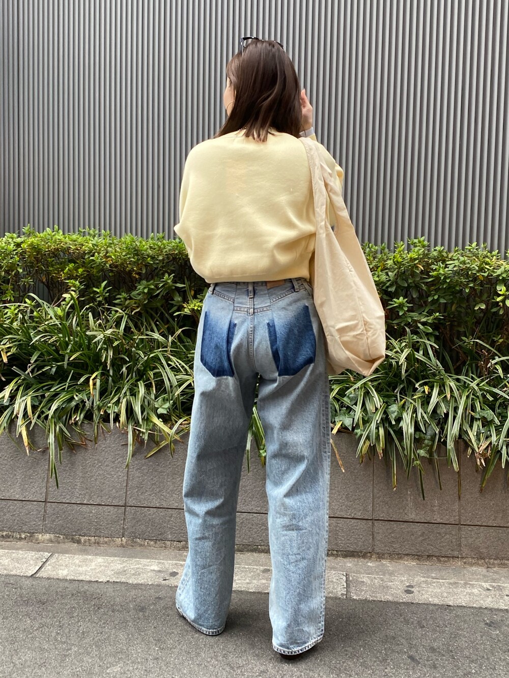 ブルー系のデニムパンツ、ブラック系のブーツ、イエロー系のニット/セーターを着用したレディースの冬コーディネートの3枚目の写真