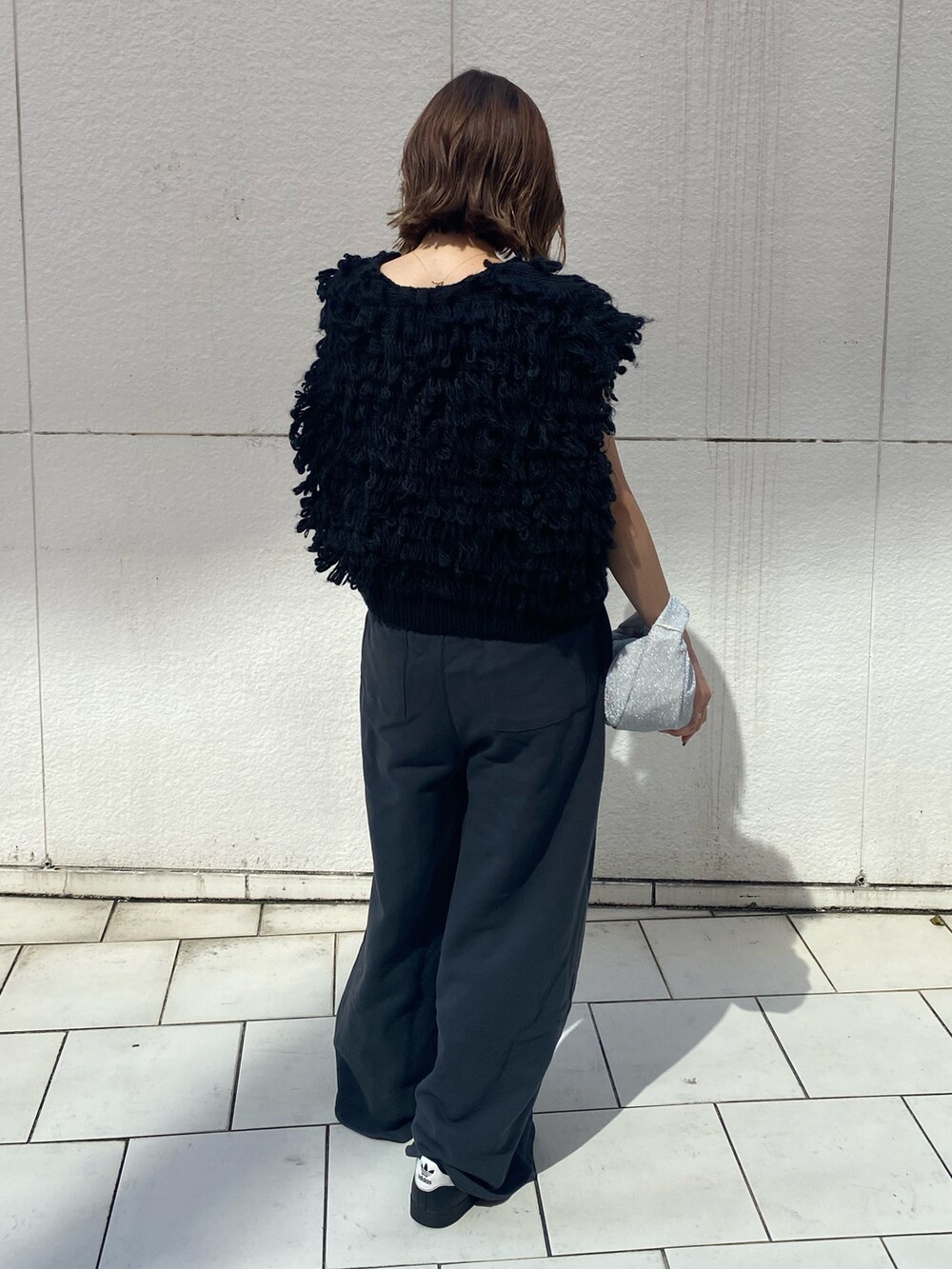 ブラック系のハンドバッグ、グレー系のスウェットパンツ、ブラック系のベストを着用したレディースの秋コーディネートの3枚目の写真