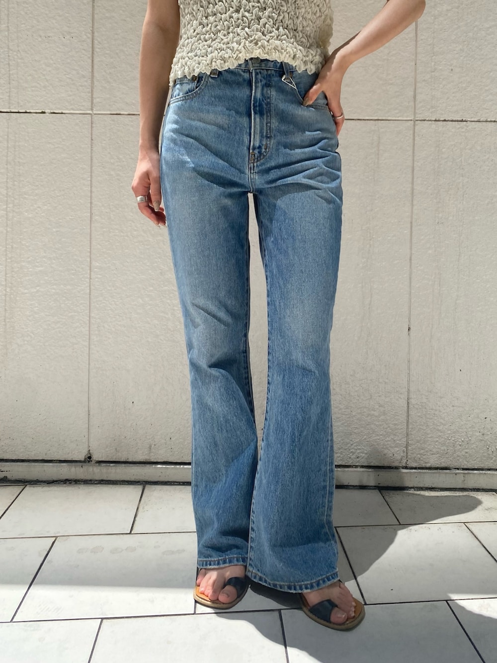 ブルー系のデニムパンツ、ホワイト系のシャツ/ブラウス、ブラック系のサンダルを着用したレディースの夏コーディネートの5枚目の写真