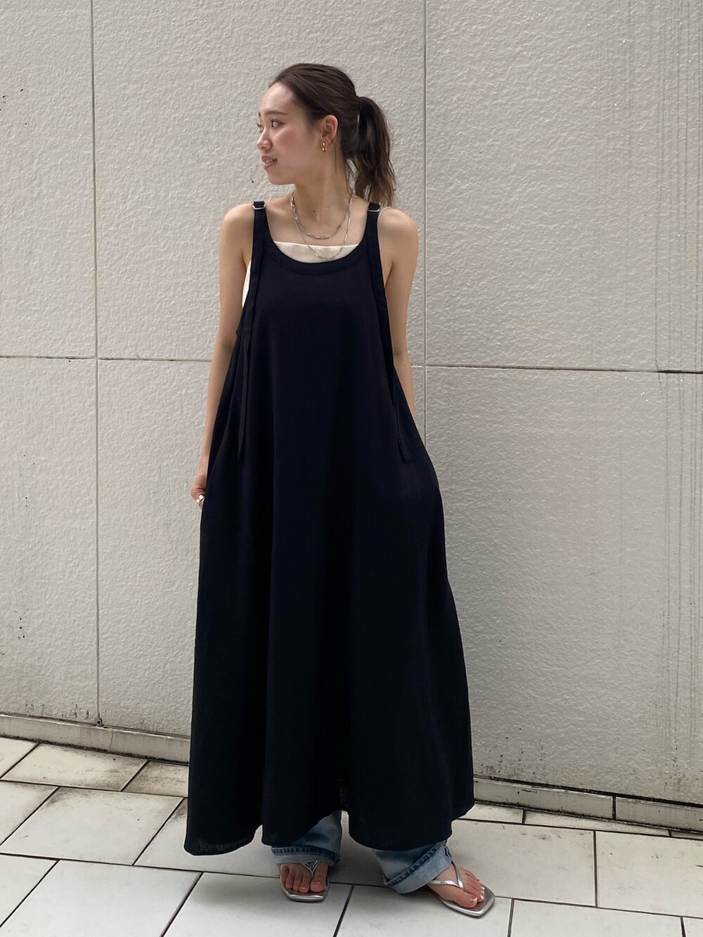 ブラック系のワンピース、ホワイト系のキャミソール、ブルー系のデニムパンツを着用したレディースの夏コーディネートの2枚目の写真