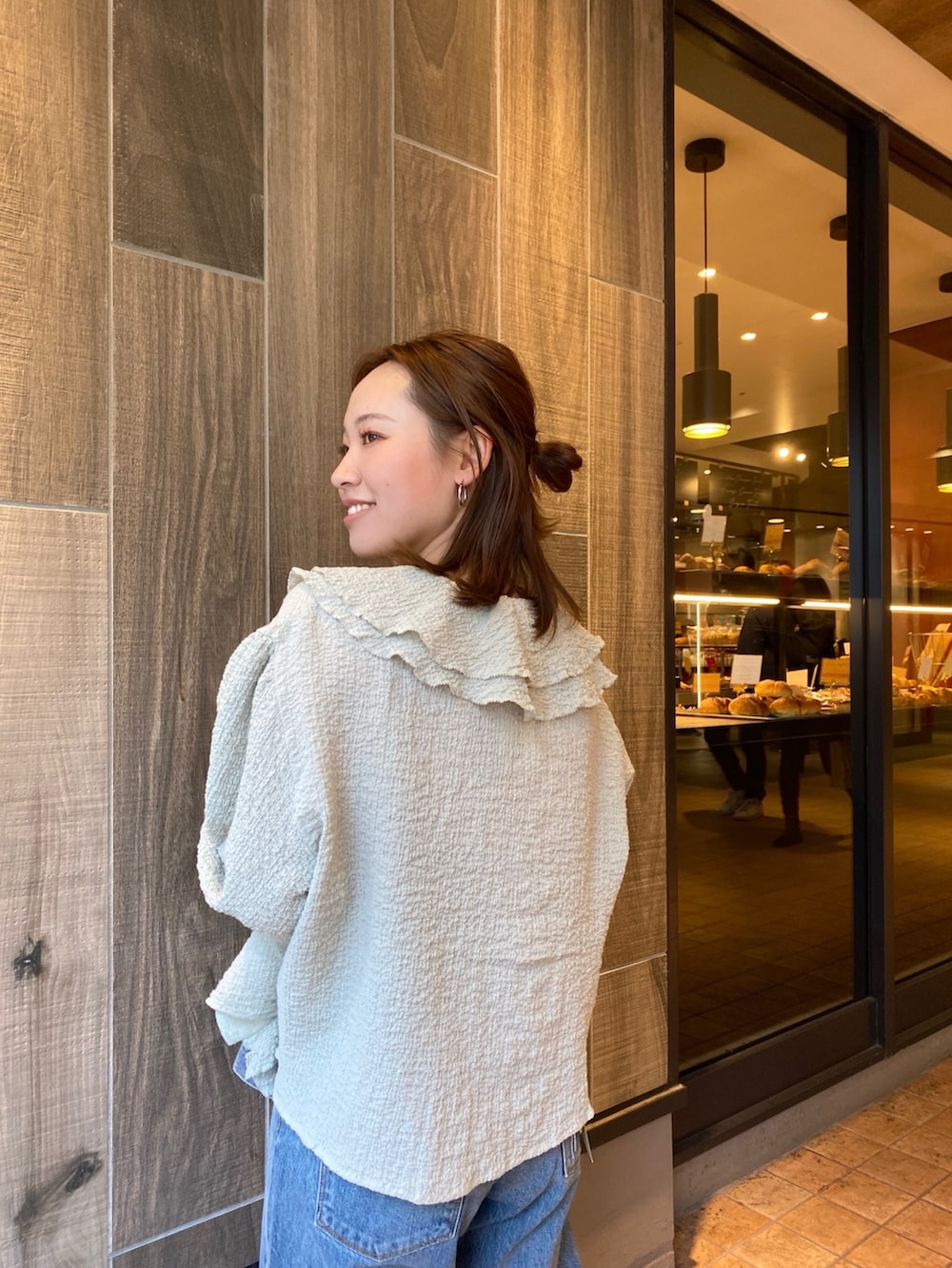 ブルー系のデニムジャケット、グリーン系のシャツ/ブラウス、ブルー系のデニムパンツを着用したレディースの春コーディネートの6枚目の写真