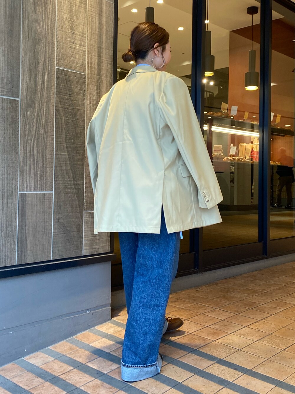 ベージュ系のテーラードジャケット、ブルー系のデニムパンツ、ブラウン系のローファーを着用したレディースの冬コーディネートの3枚目の写真