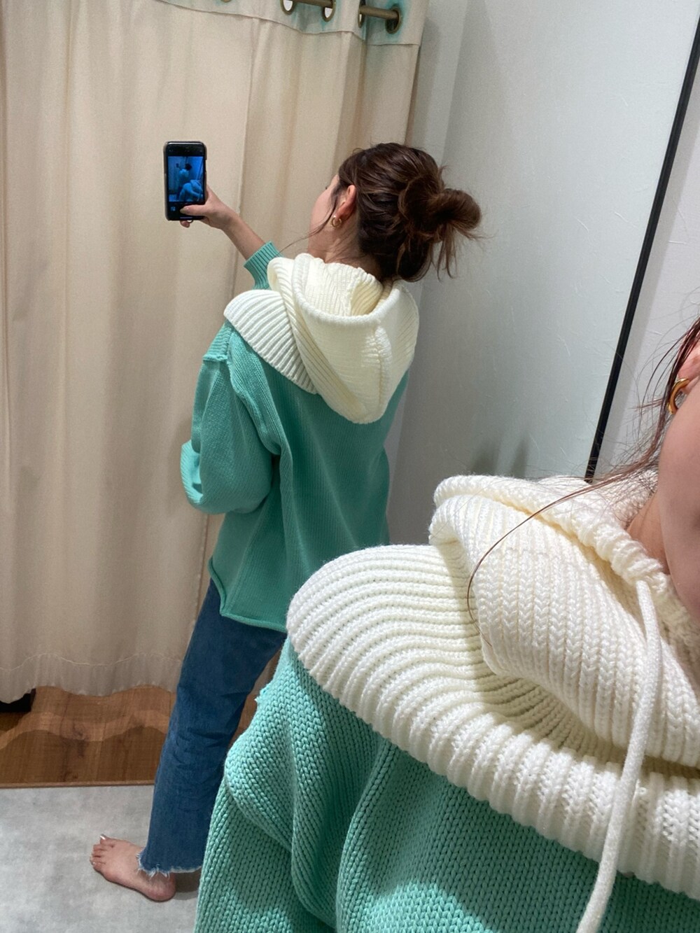 グリーン系のニット/セーター、ブルー系のデニムパンツを着用したレディースの秋コーディネートの4枚目の写真