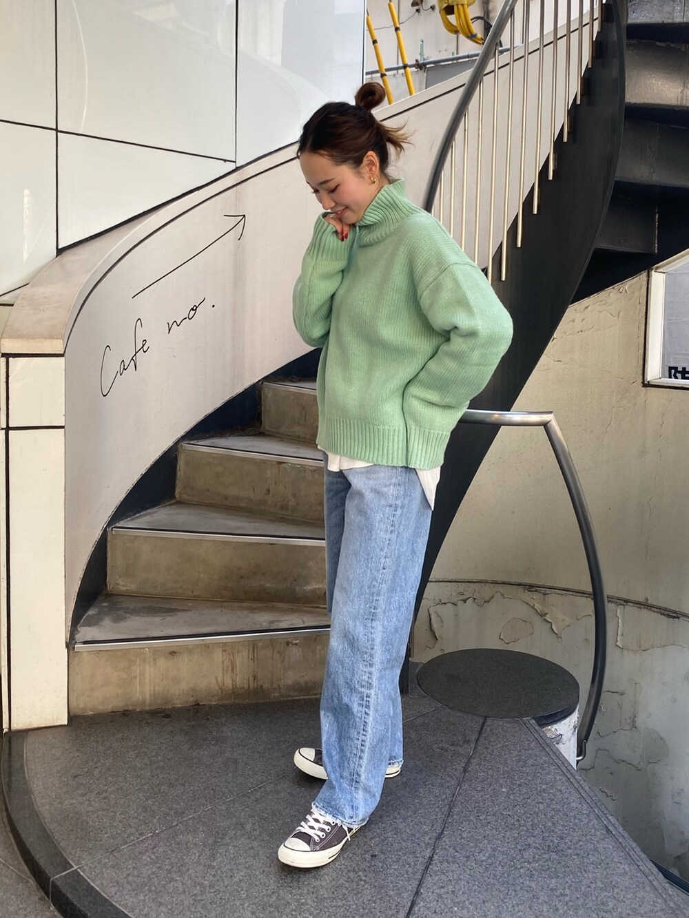 ブルー系のデニムパンツ、グリーン系のニット/セーター、ホワイト系のTシャツ/カットソーを着用したレディースの秋コーディネートの2枚目の写真