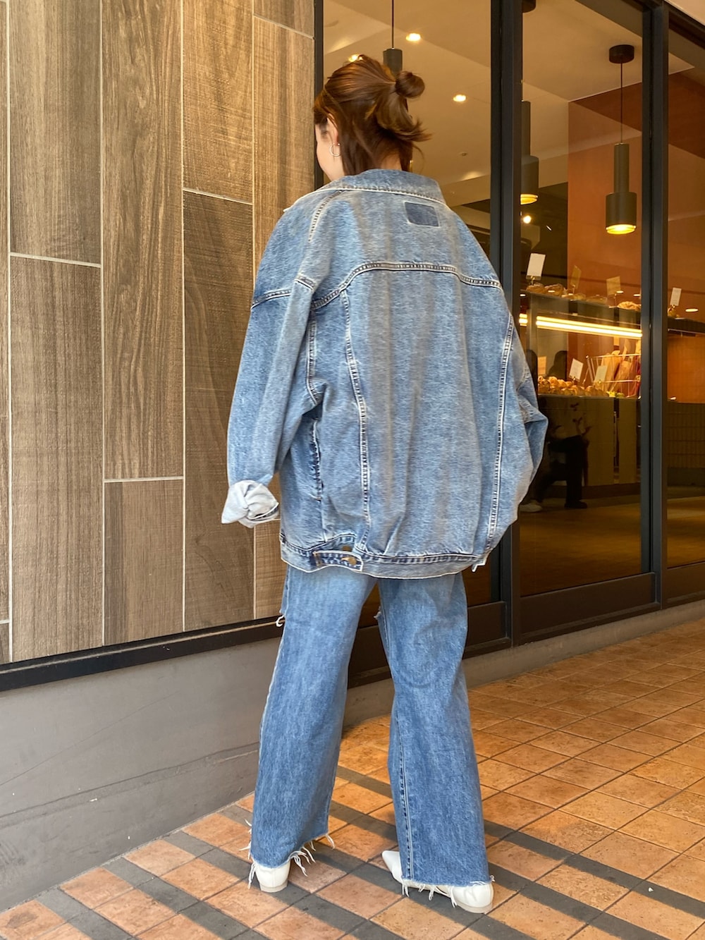 ブルー系のデニムジャケット、グリーン系のシャツ/ブラウス、ブルー系のデニムパンツを着用したレディースの春コーディネートの3枚目の写真