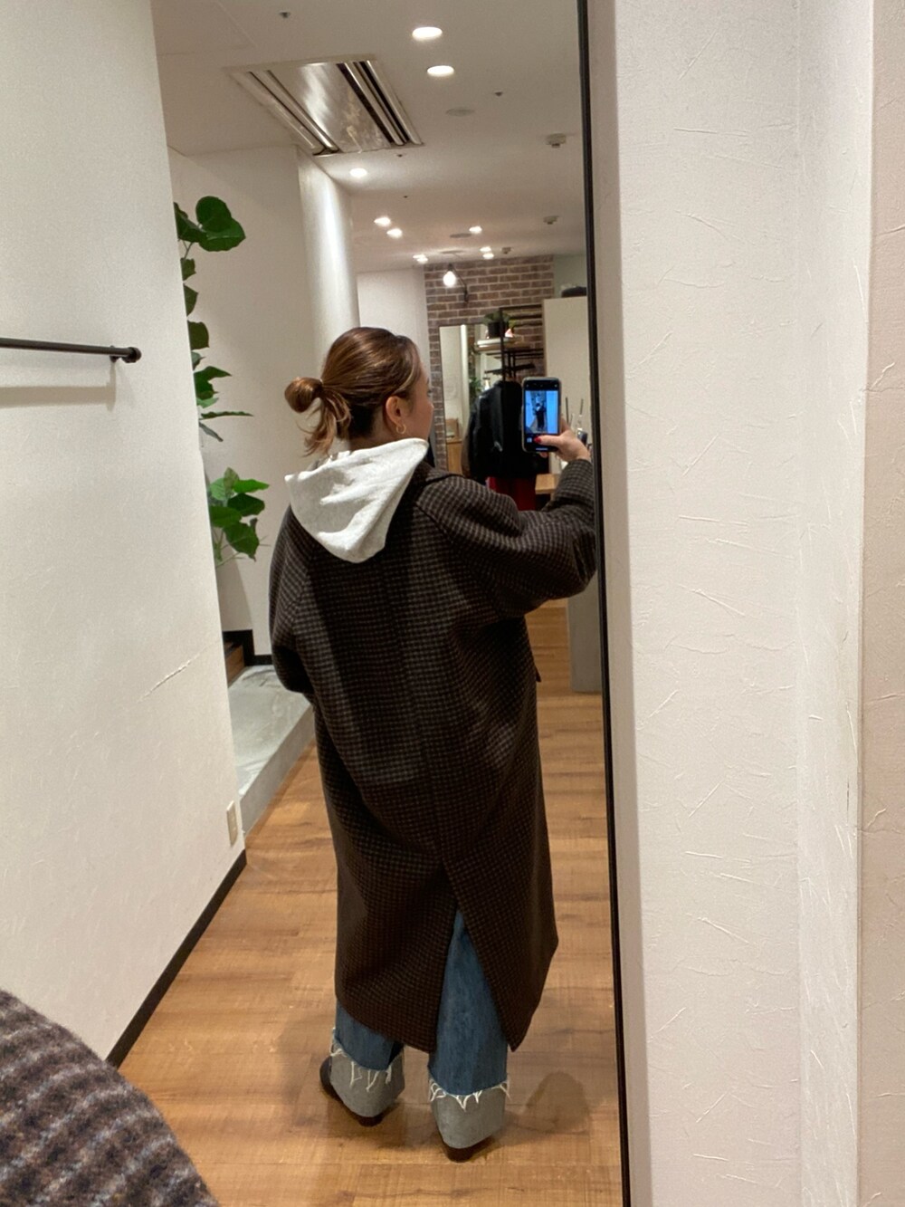 その他のチェスターコート、ブルー系のデニムパンツ、ブラック系のブーツを着用したレディースの秋コーディネートの3枚目の写真