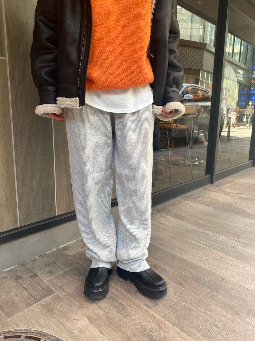 ブラック系のムートンコート、グレー系のその他パンツ、ブラック系のブーツを着用したレディースの秋コーディネートの4枚目の写真