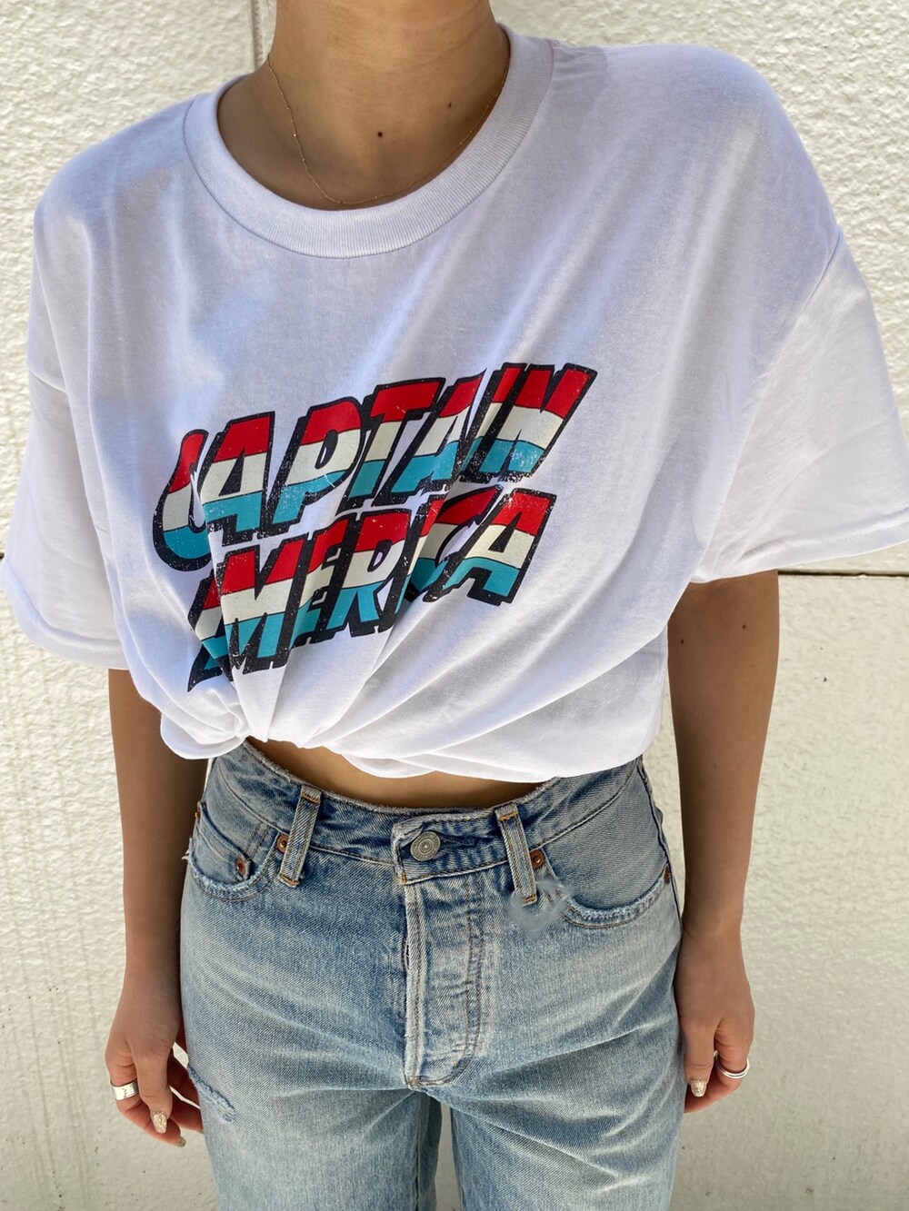 ブルー系のデニムパンツ、ホワイト系のサンダル、ホワイト系のTシャツ/カットソーを着用したレディースの夏コーディネートの7枚目の写真