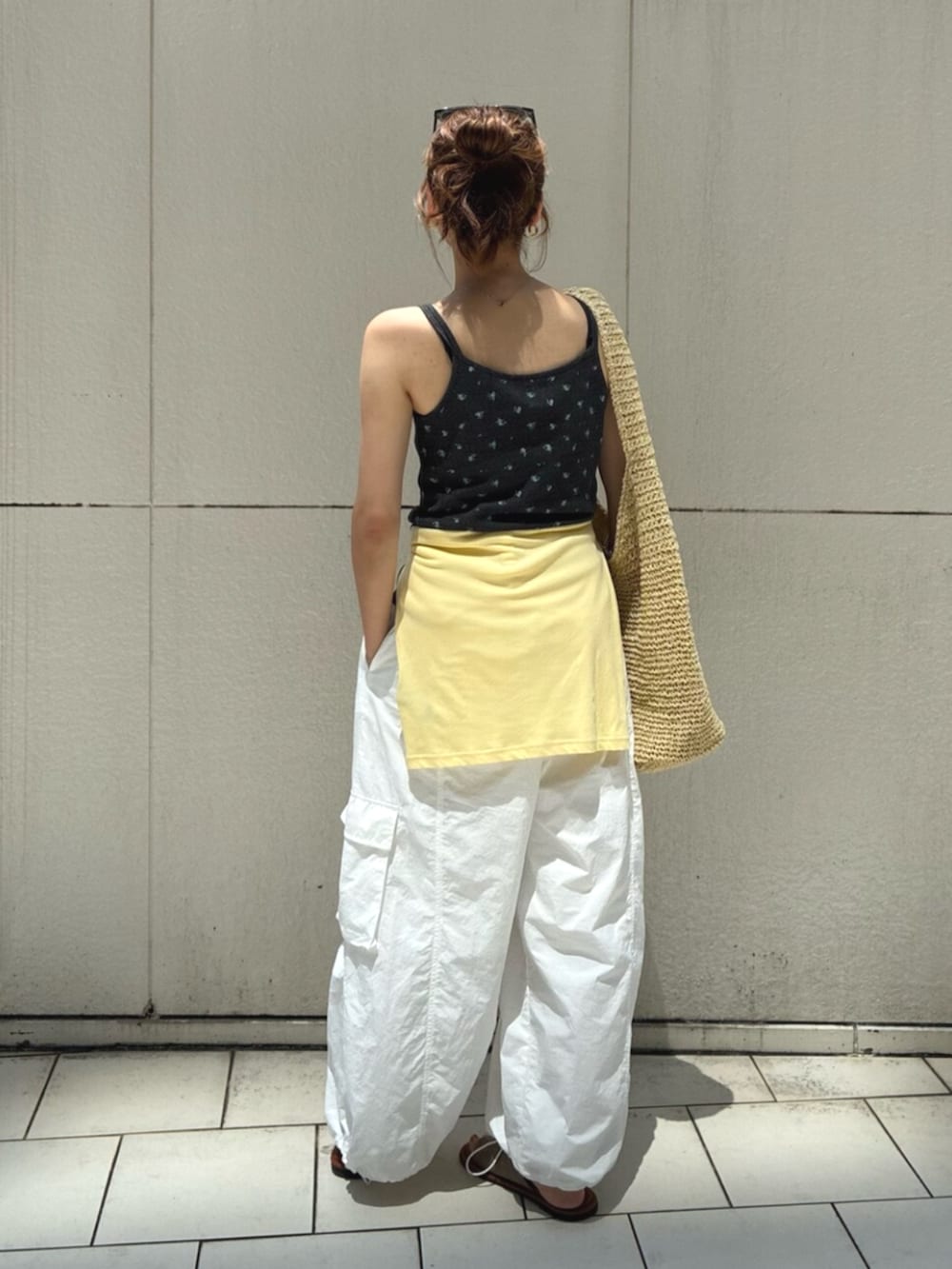 グレー系のキャミソール、イエロー系のTシャツ/カットソー、ベージュ系のショルダーバッグを着用したレディースの夏コーディネートの3枚目の写真