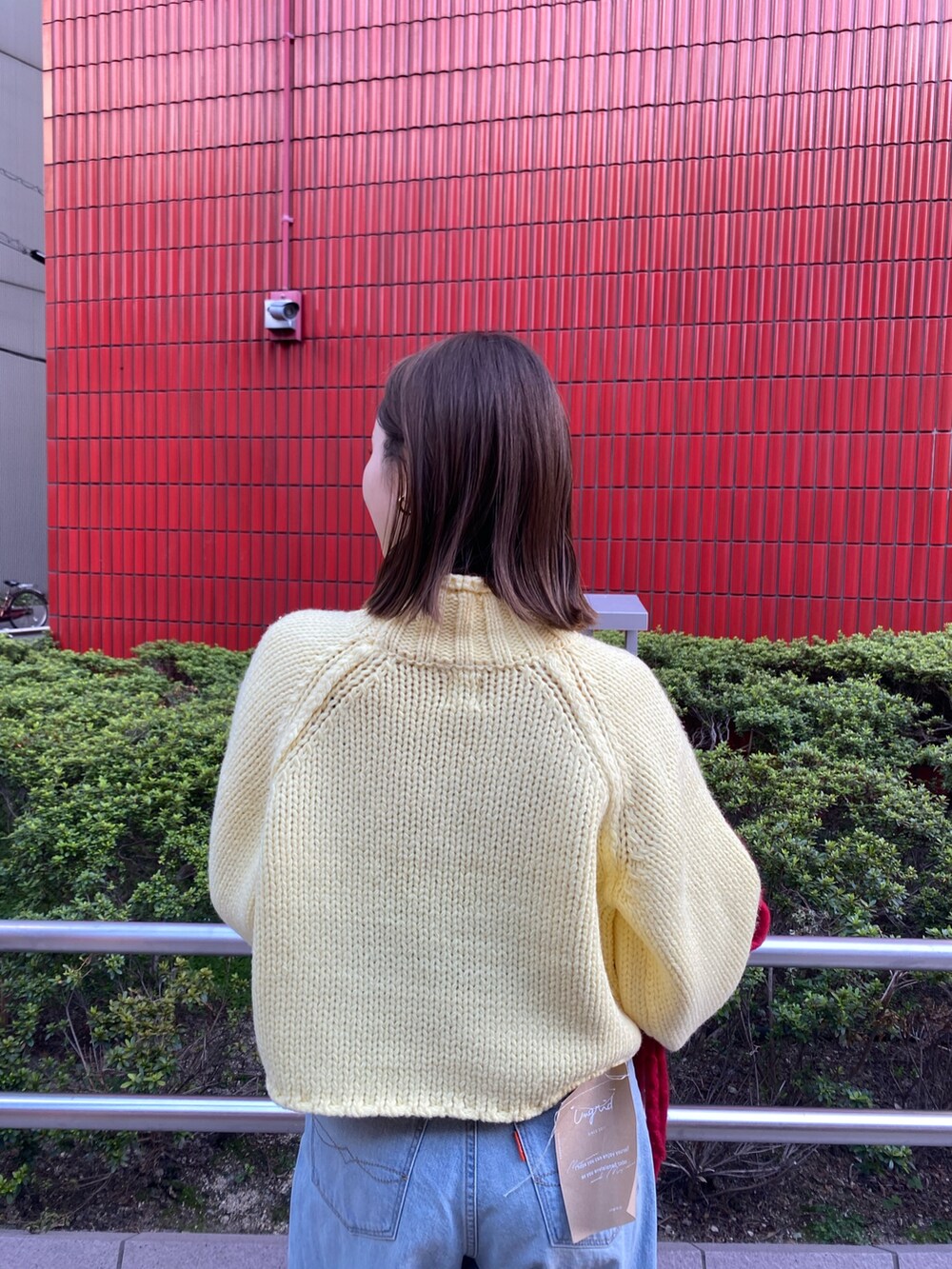 ブルー系のデニムパンツ、イエロー系のニット/セーター、ブラウン系のブーツを着用したレディースの秋コーディネートの6枚目の写真