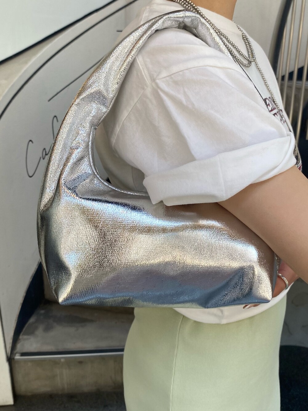 グリーン系のワンピース、ホワイト系のTシャツ/カットソー、シルバー系のハンドバッグを着用したレディースの春コーディネートの5枚目の写真