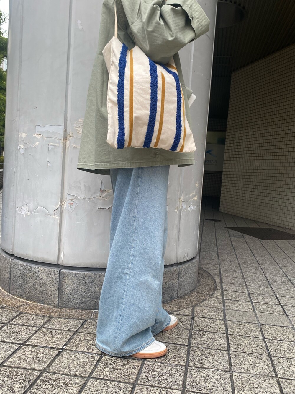 ブルー系のデニムパンツ、グリーン系のミリタリージャケット、ホワイト系のTシャツ/カットソーを着用したレディースの春コーディネートの7枚目の写真