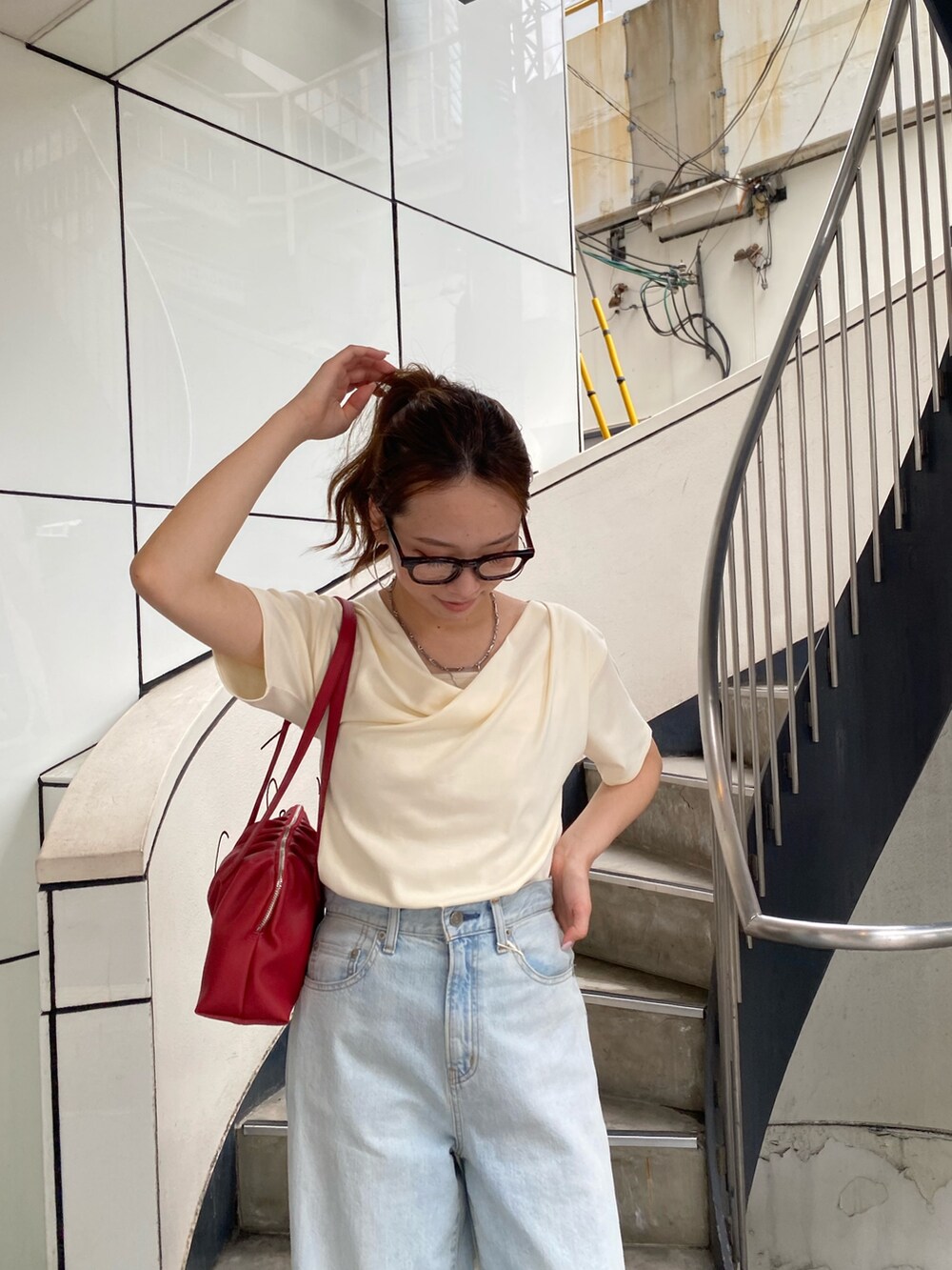 ブルー系のデニムパンツ、ブラック系のサンダル、ホワイト系のTシャツ/カットソーを着用したレディースの夏コーディネートの4枚目の写真