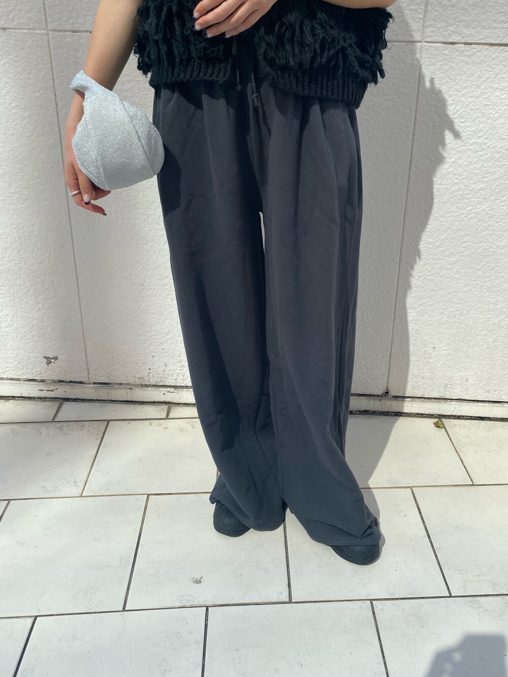 ブラック系のハンドバッグ、グレー系のスウェットパンツ、ブラック系のベストを着用したレディースの秋コーディネートの7枚目の写真