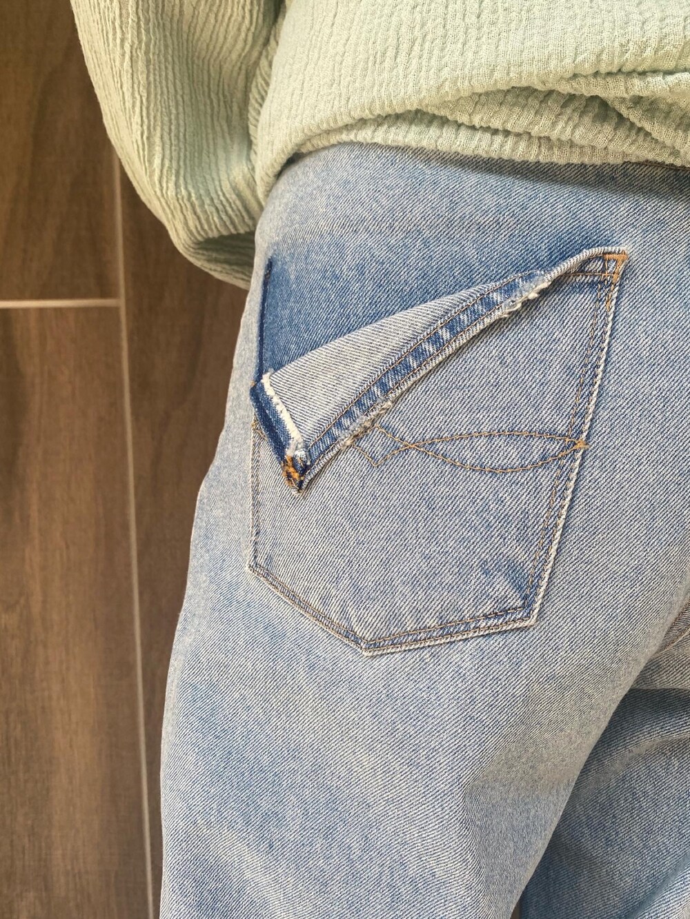 グリーン系のシャツ/ブラウス、ブルー系のデニムパンツ、ホワイト系のハンドバッグを着用したレディースの春コーディネートの4枚目の写真